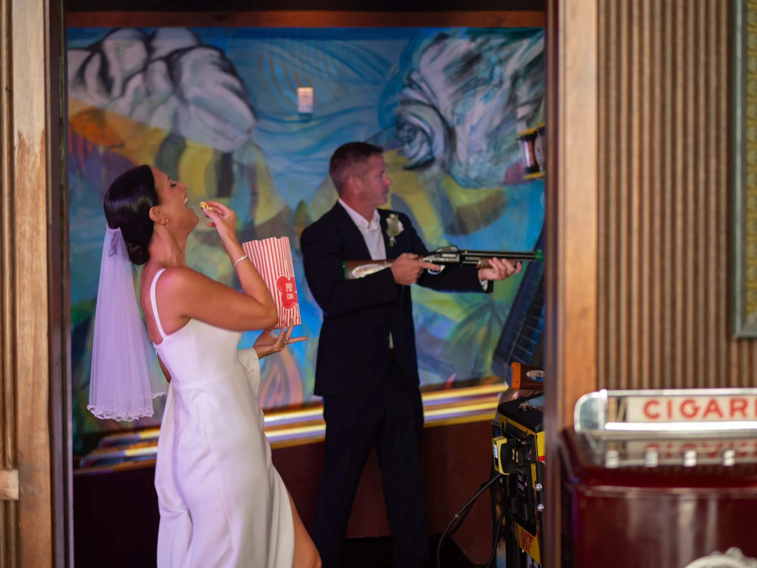 Bride and groom sharing a playful moment beside colorful artwork inside Perry Lane Hotel