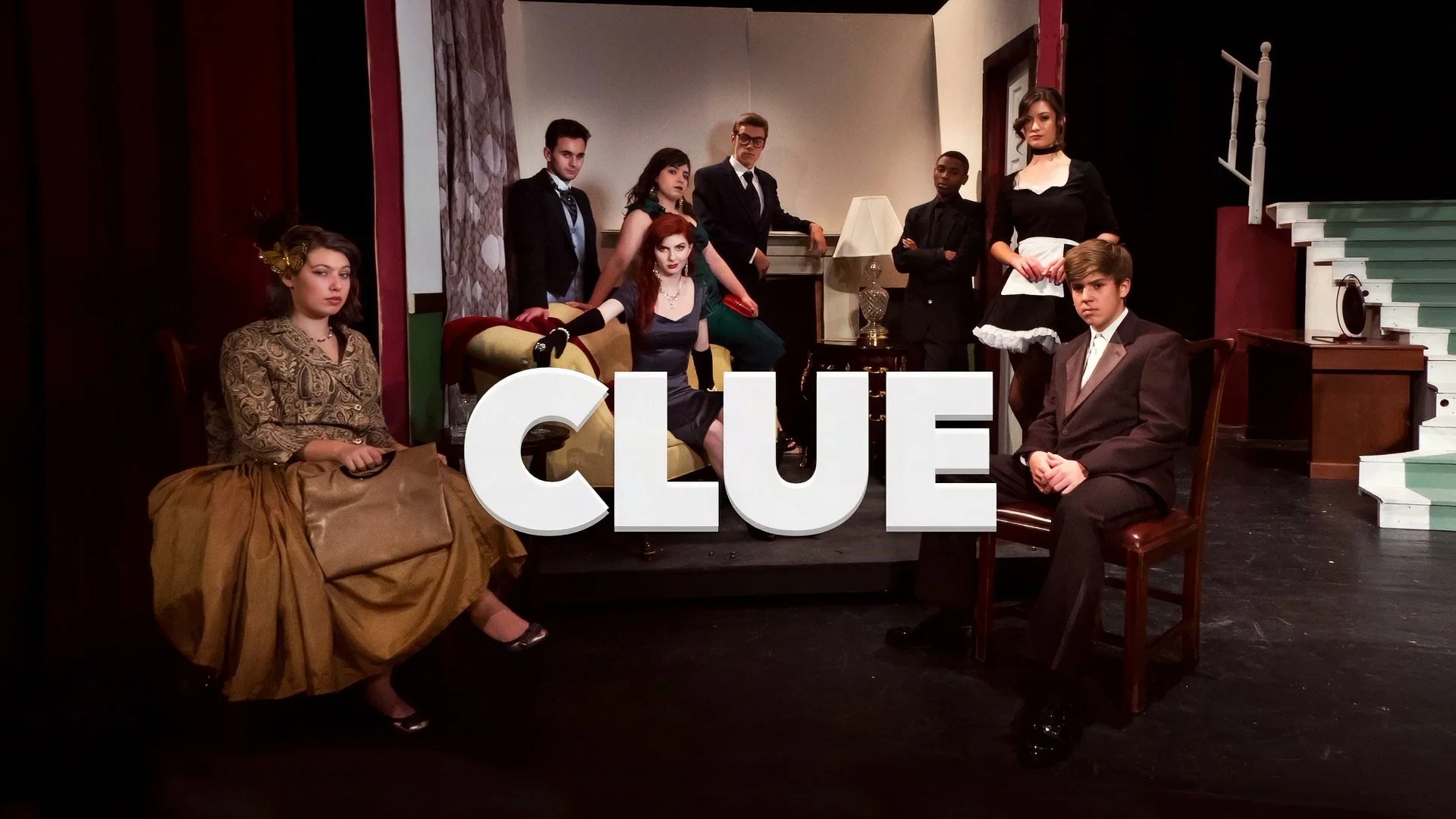 Posed promotional portrait featuring the cast of Sheehan High School's Clue, photographed together on the theatrical stage set.