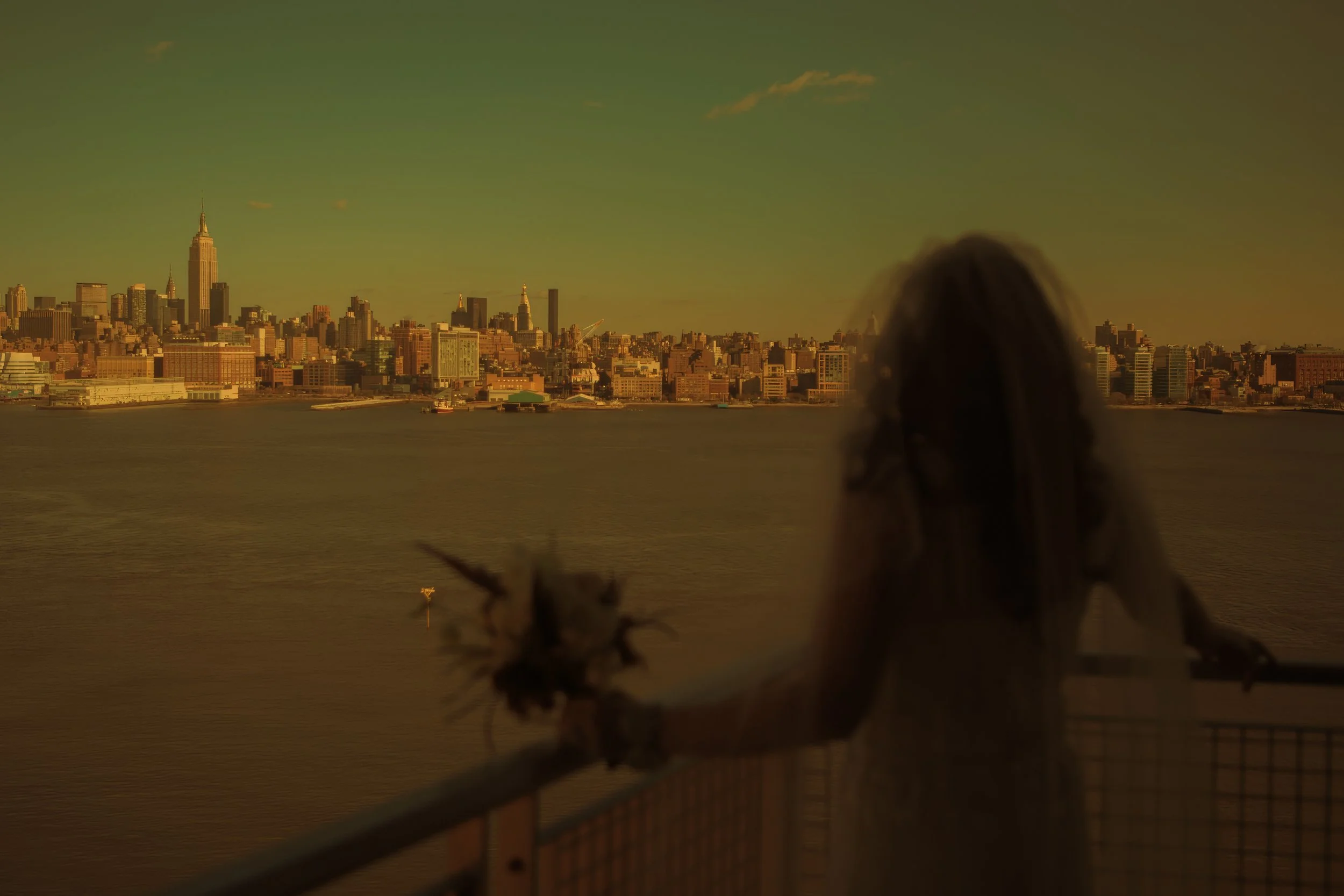 Silhouette of the bride looking out from the balcony toward the Manhattan skyline at W Hoboken.