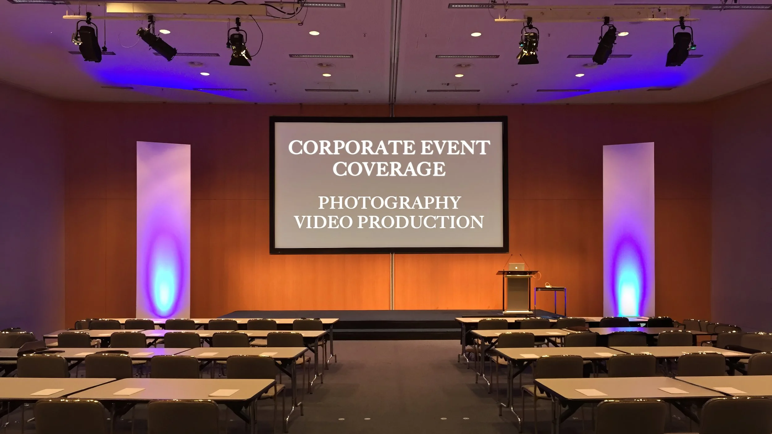 Wide view of a Connecticut corporate event stage with branded screens, podium, and professional lighting setup.