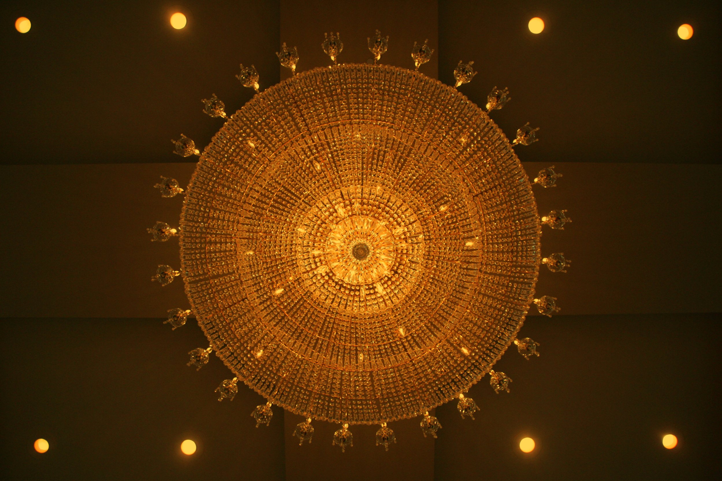 Grand chandelier hanging over a Bond Ballroom wedding reception.