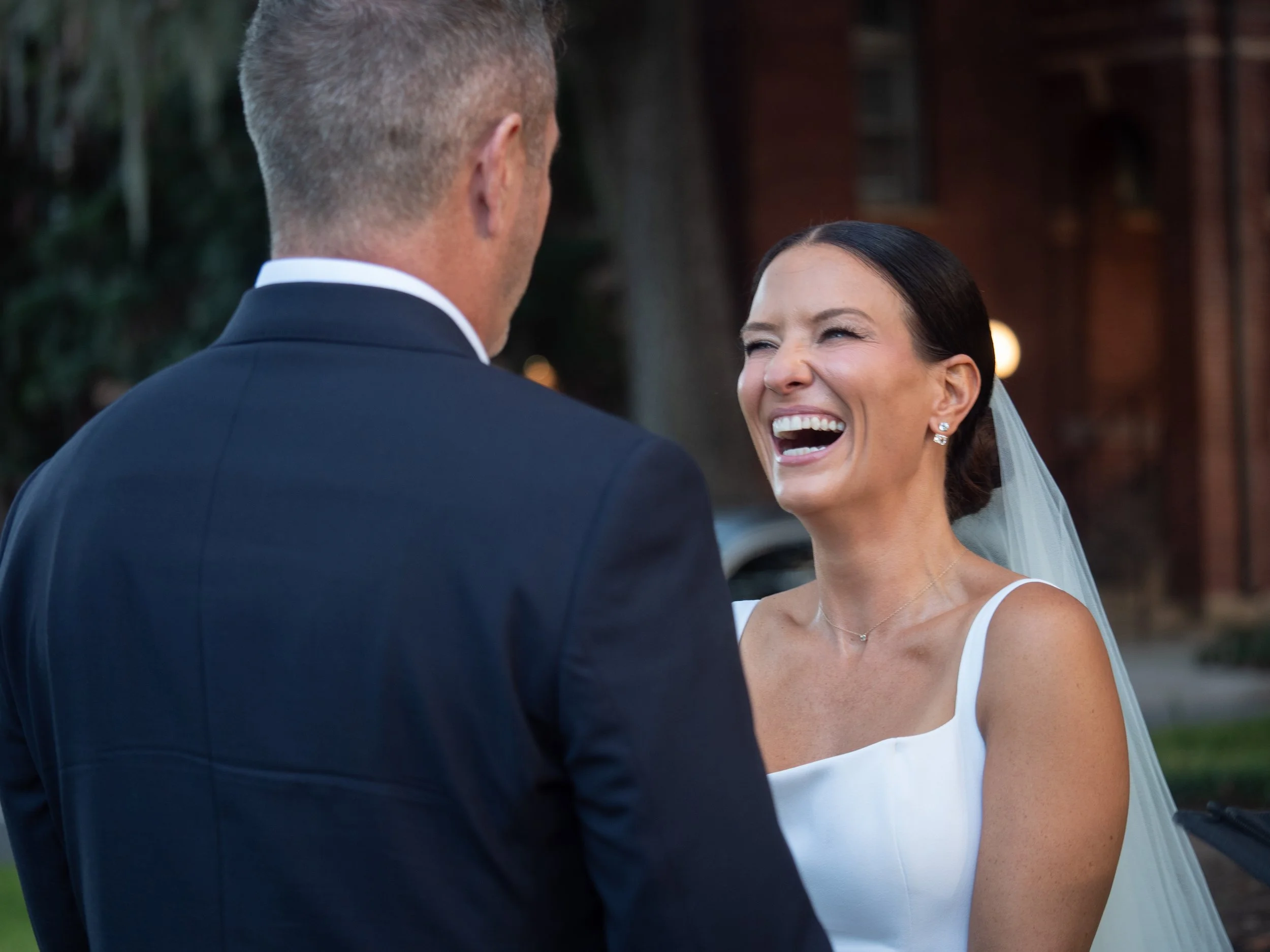 Bride laughing as she faces the groom during their intimate wedding ceremony in Pulaski Square