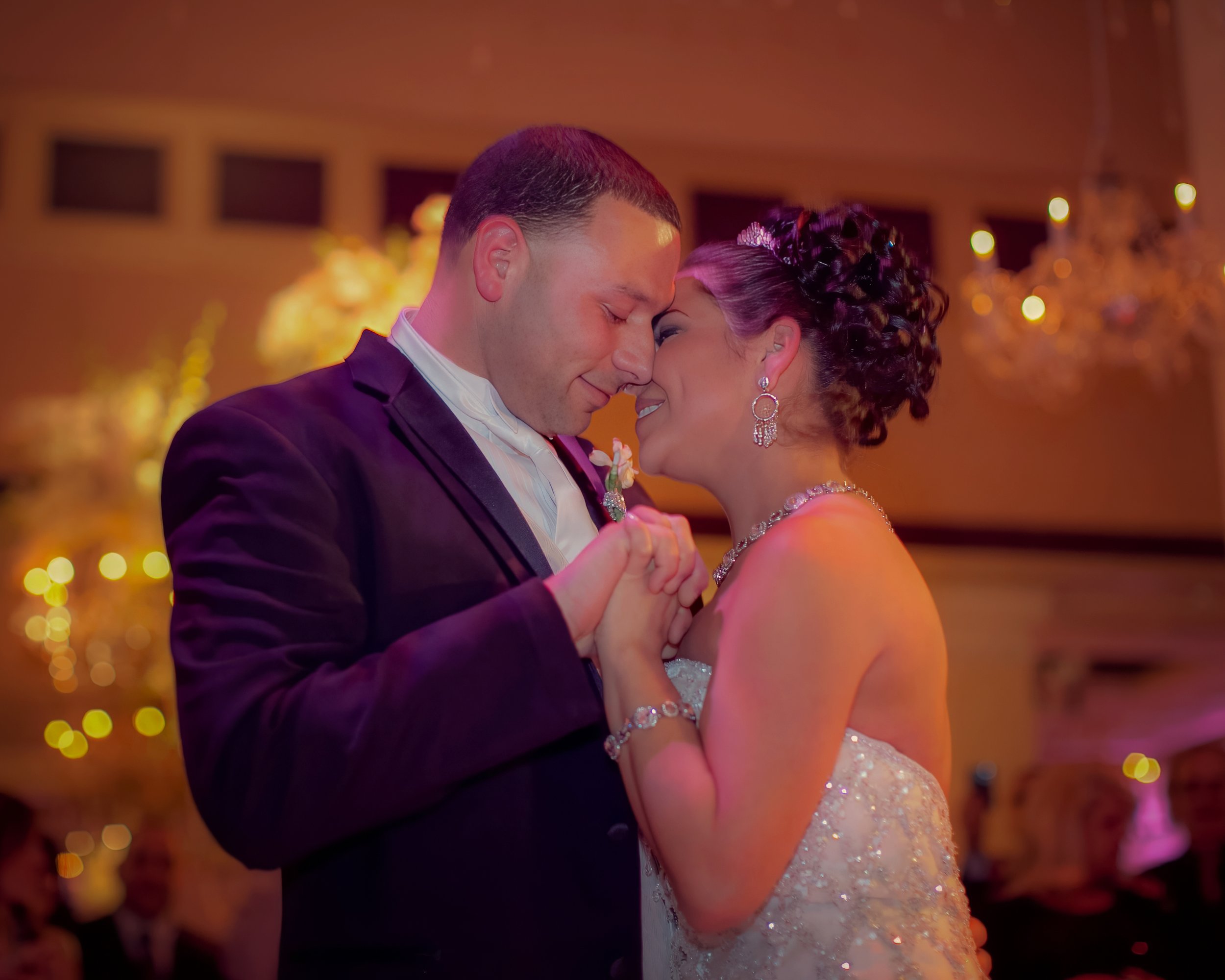 Bride and groom share an emotional first dance in the ballroom.