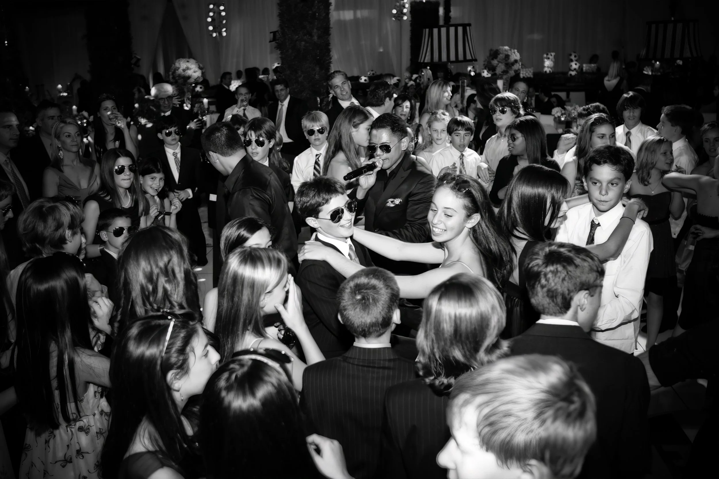 Friends surrounding the Bar Mitzvah boy as they celebrate together on the dance floor during the reception.