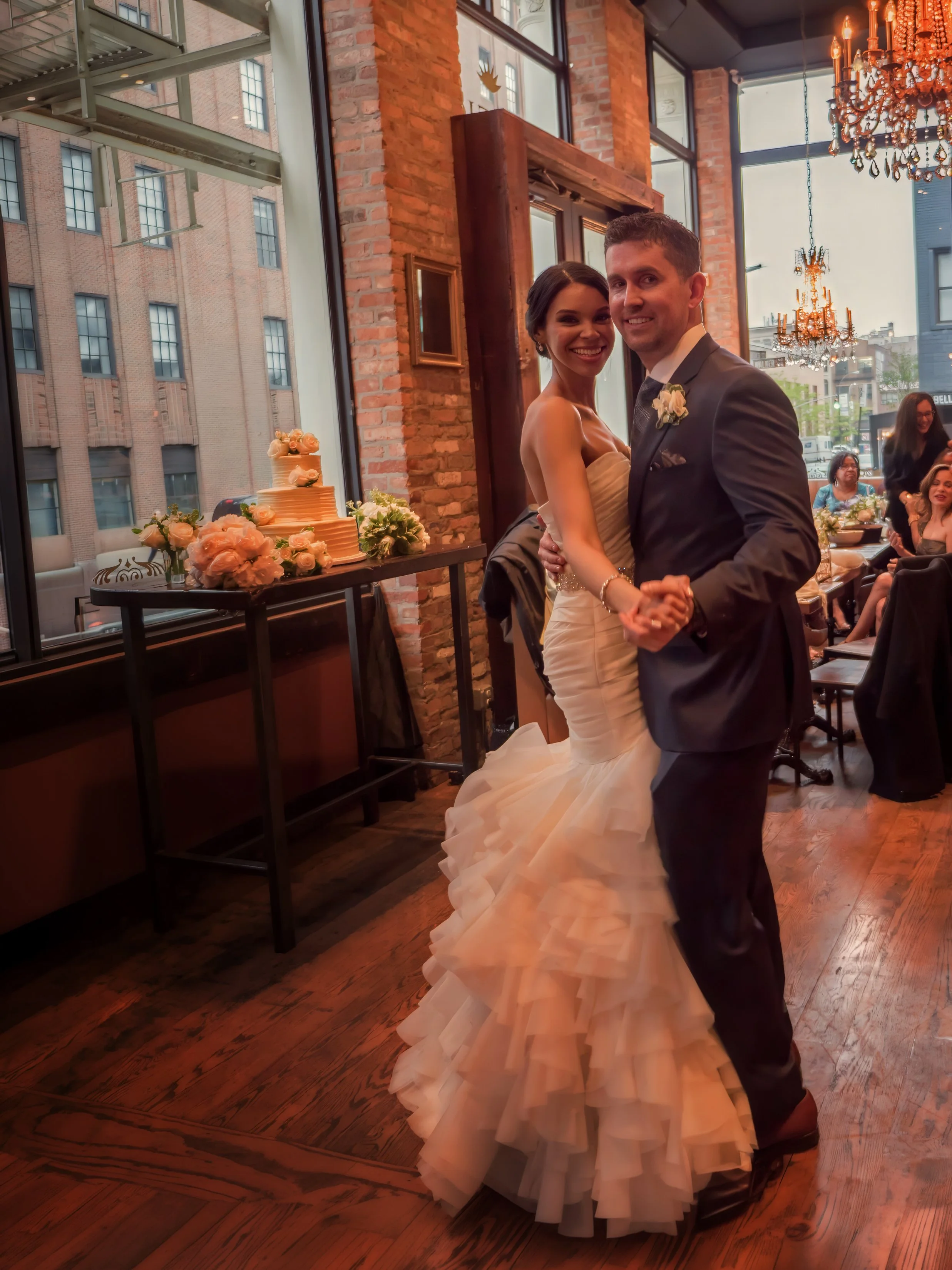 Bride and groom dance together and look toward the camera during their NYC wedding reception at Añejo.
