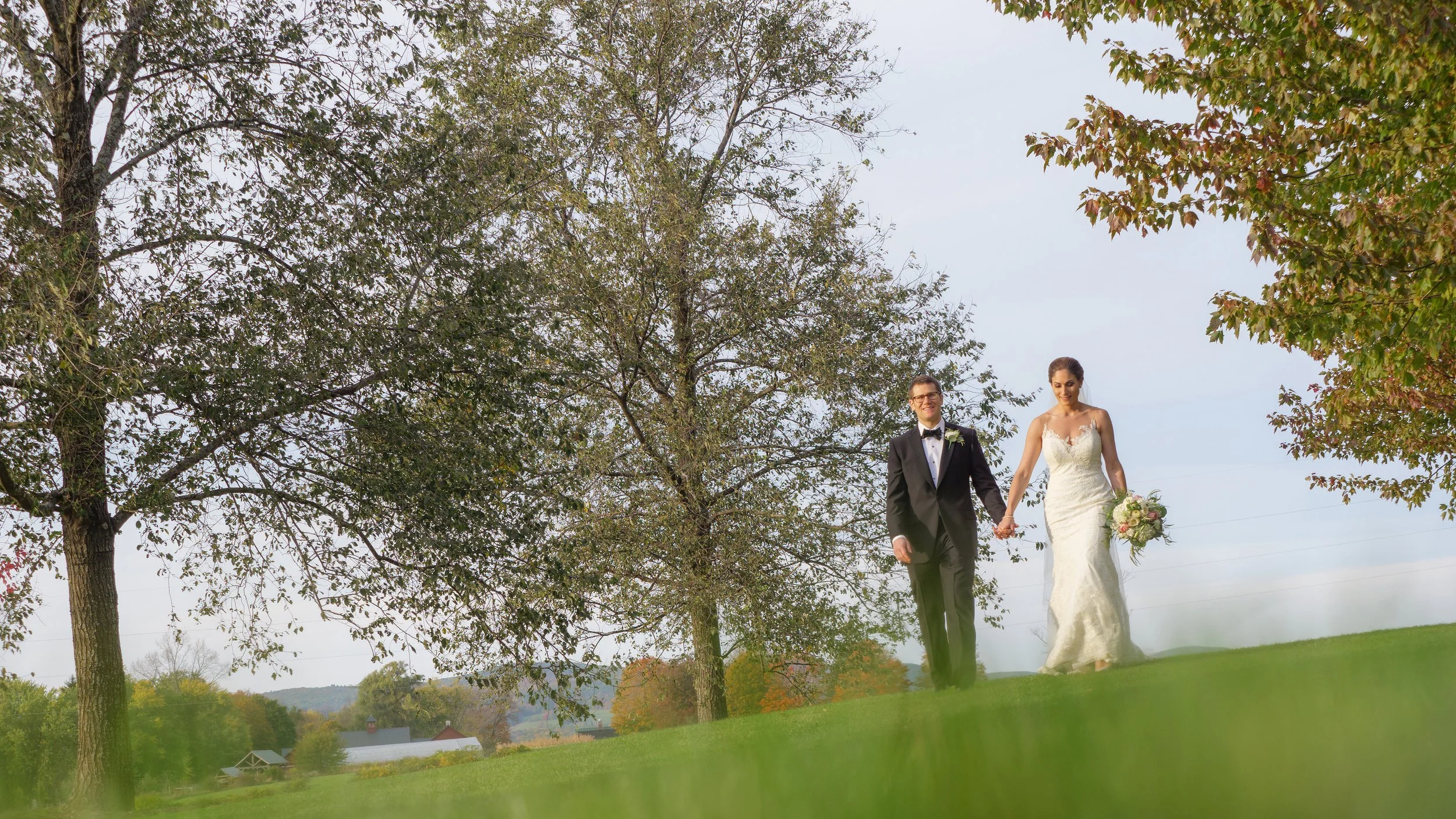 Bride and groom walking through the rolling hills of Litchfield during a private estate wedding.