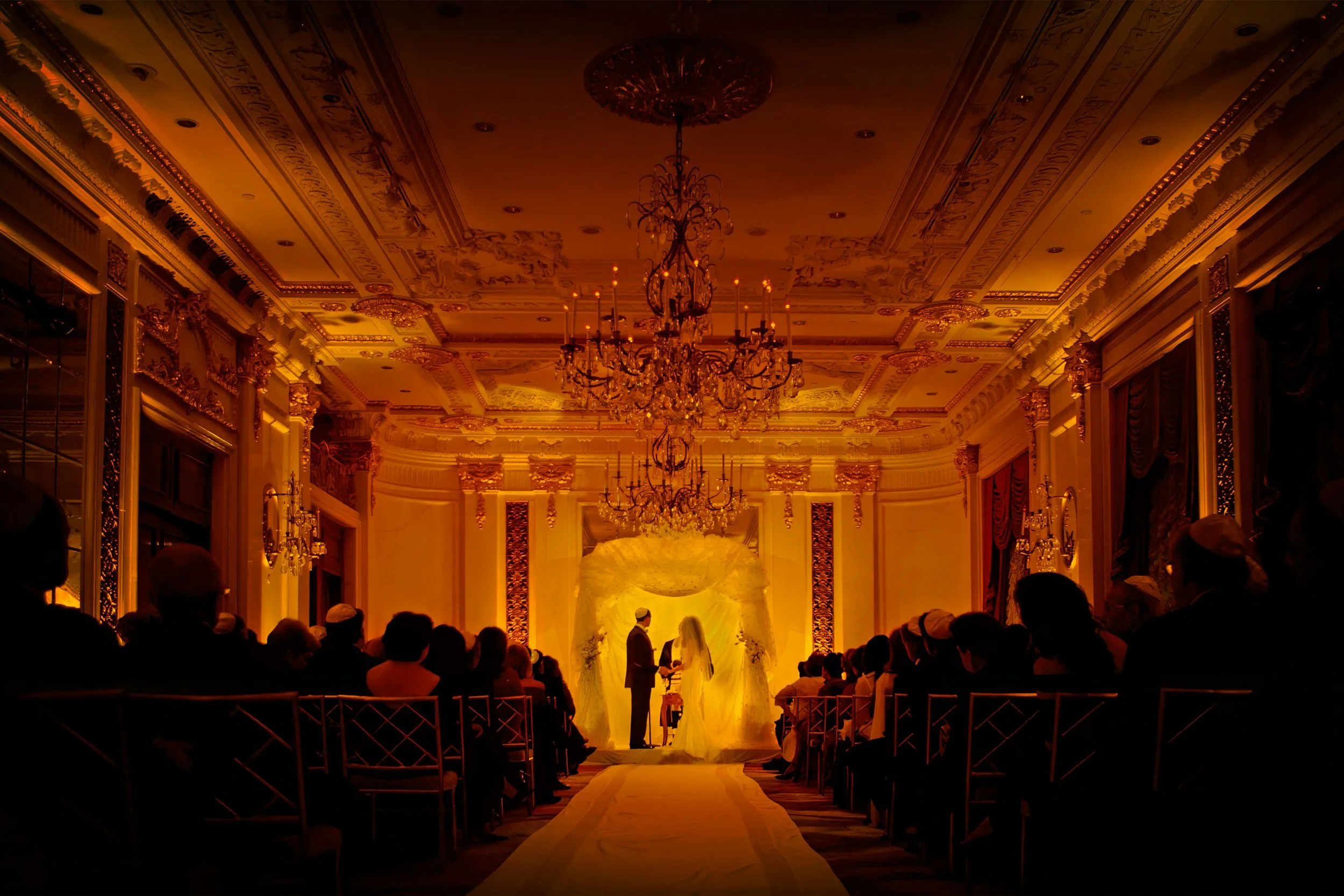 Bride and groom exchanging vows in a luxurious St. Regis New York ballroom with classic décor.