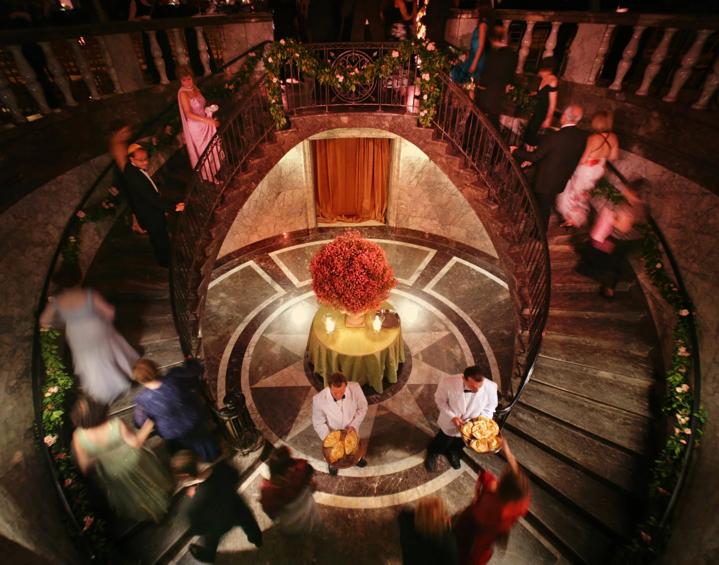 Wedding guests walking up the grand staircase toward a ceremony at the historic 48 Wall Street wedding venue in Manhattan.
