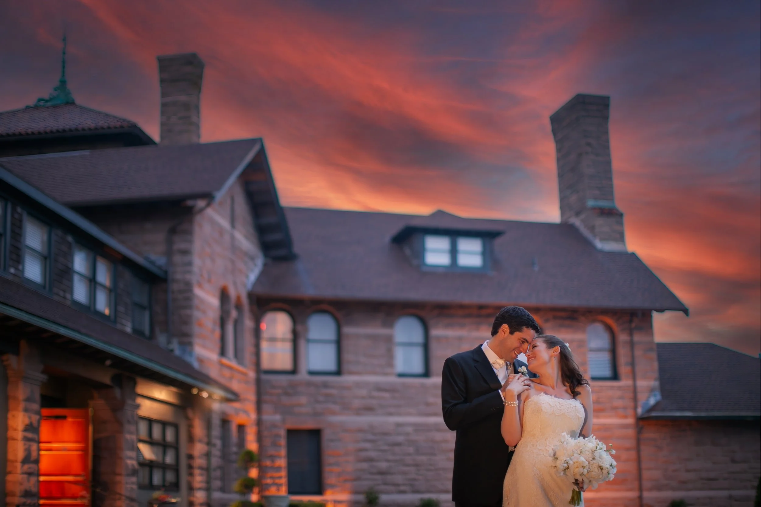 Bride and groom sharing a romantic sunset moment overlooking the ocean at OceanCliff in Newport Rhode Island.