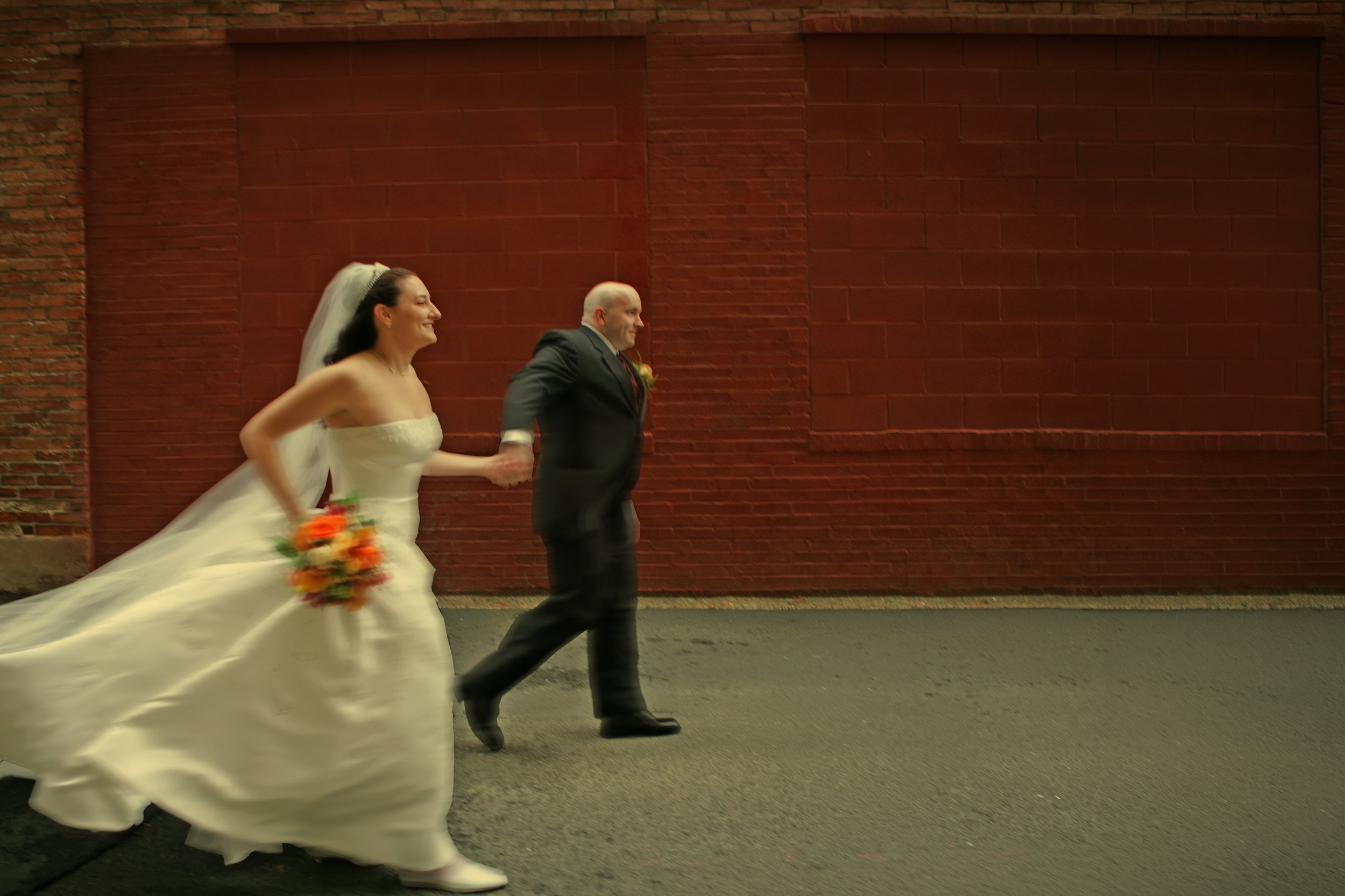 Bride and groom walk down a Downtown Hartford alley outside Bond Ballroom.