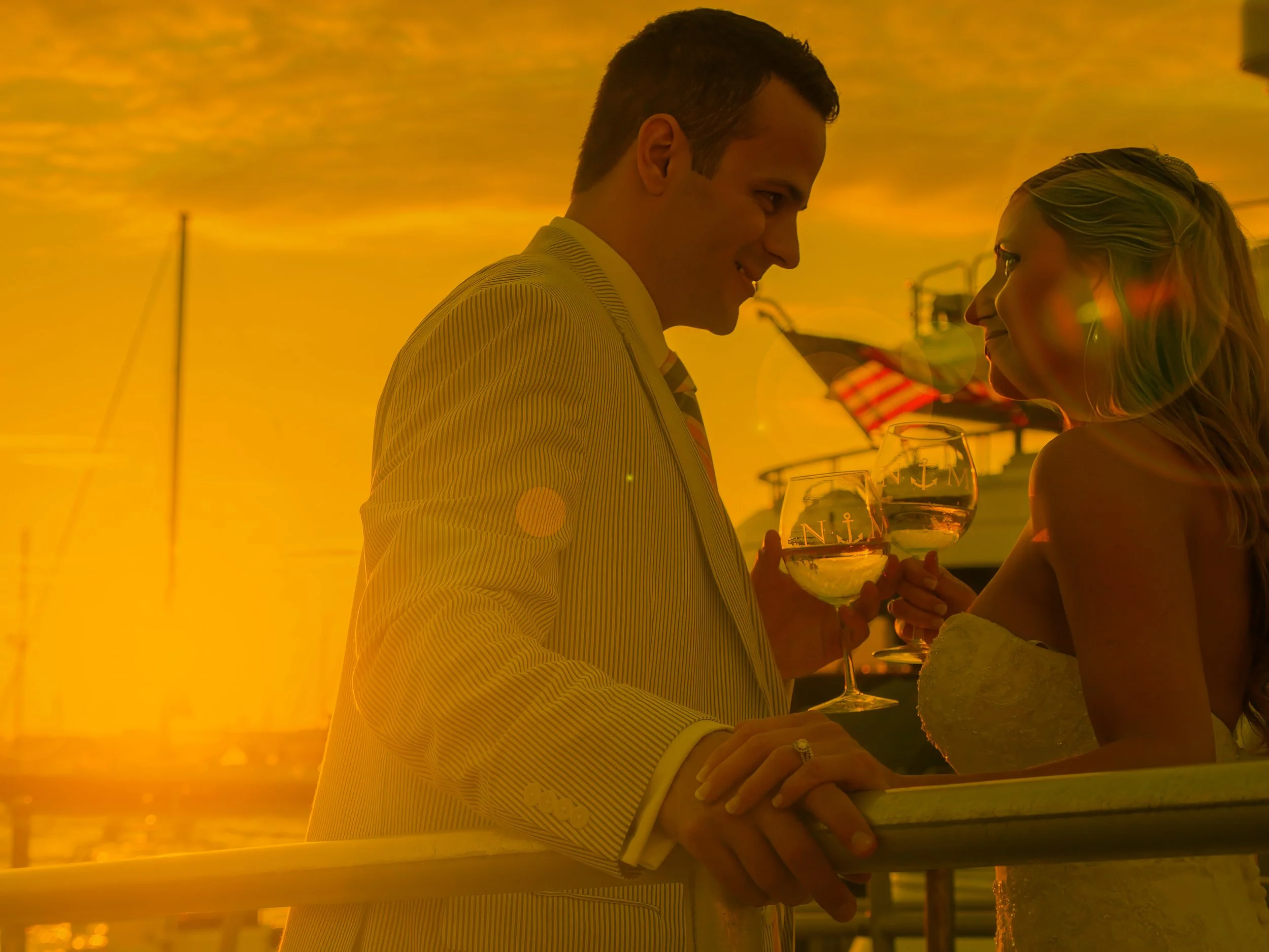 Bride and groom bask in sunlight sharing a romantic moment at Newport Yachting Center.