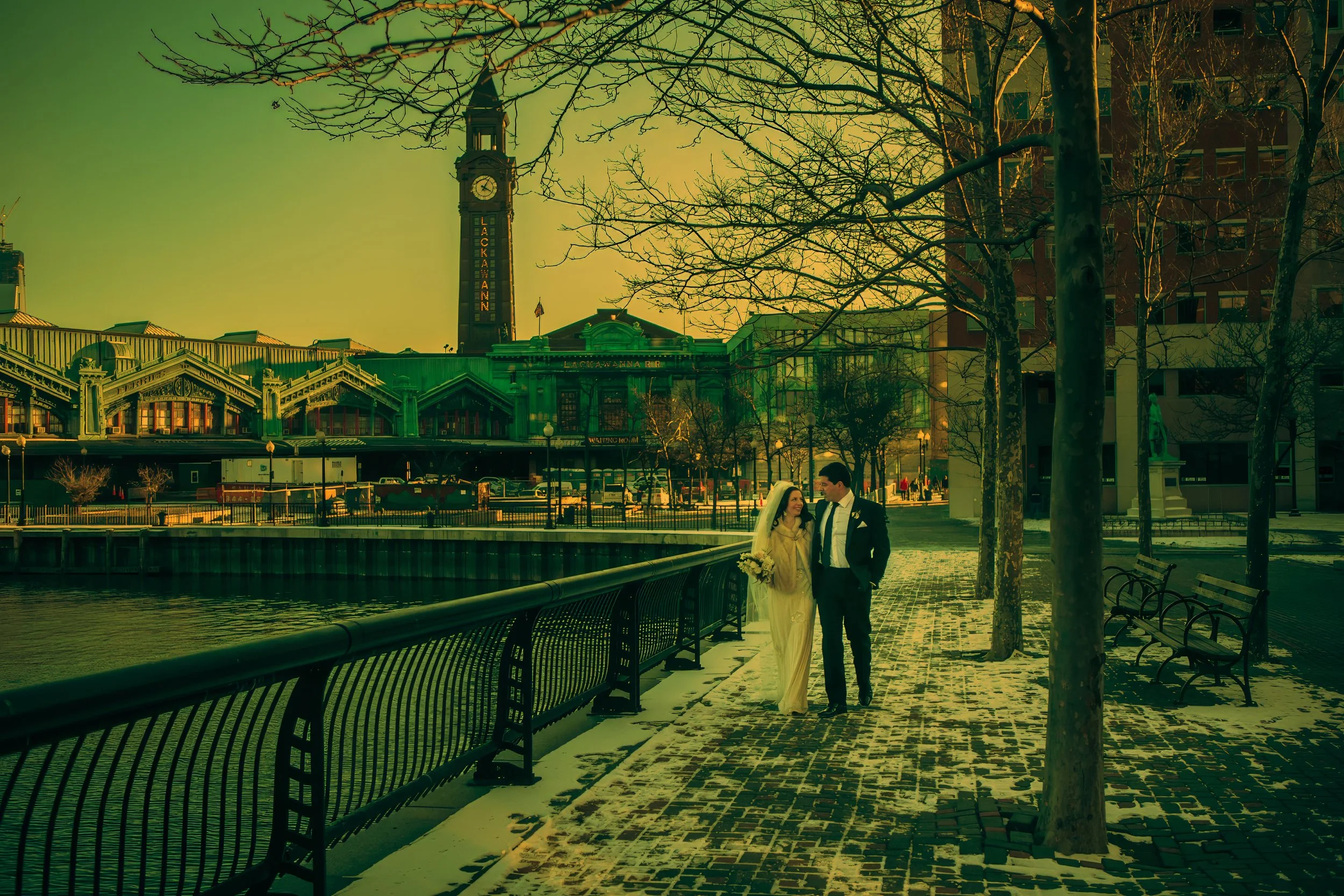 Bride and groom walk hand-in-hand through Hoboken on a winter day, captured in a cinematic photograph.