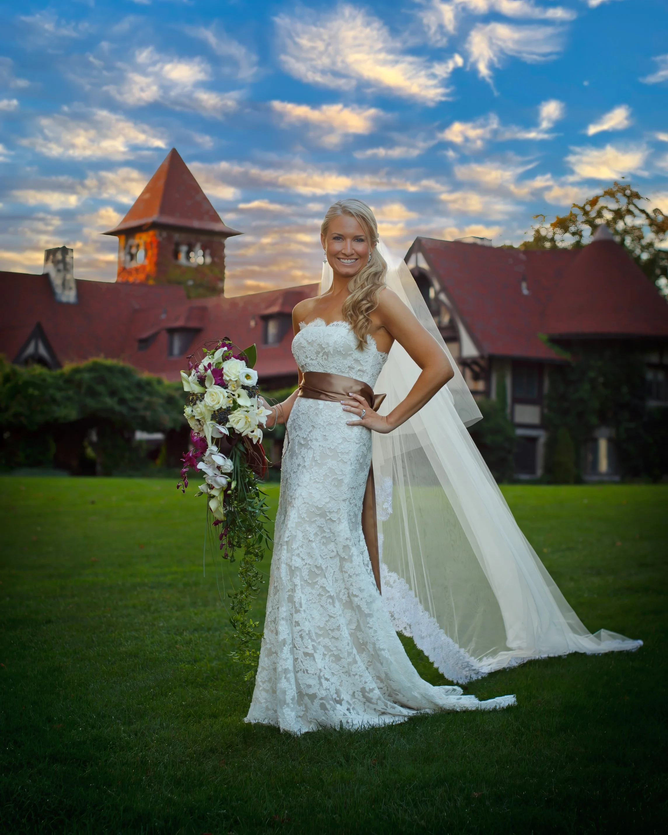 Bride posing on the lawn with Saint Clements Castle in the distance