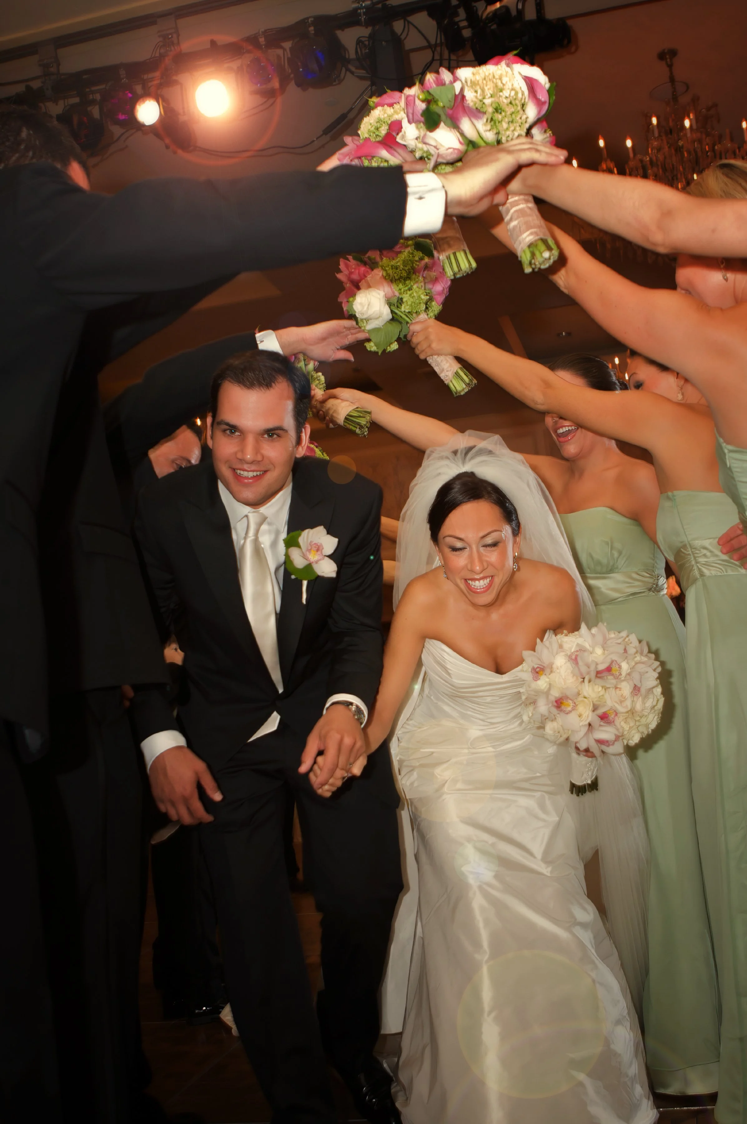 Candid moment of bride and groom’s grand entrance as friends cheer at Omni Hotel New Haven.