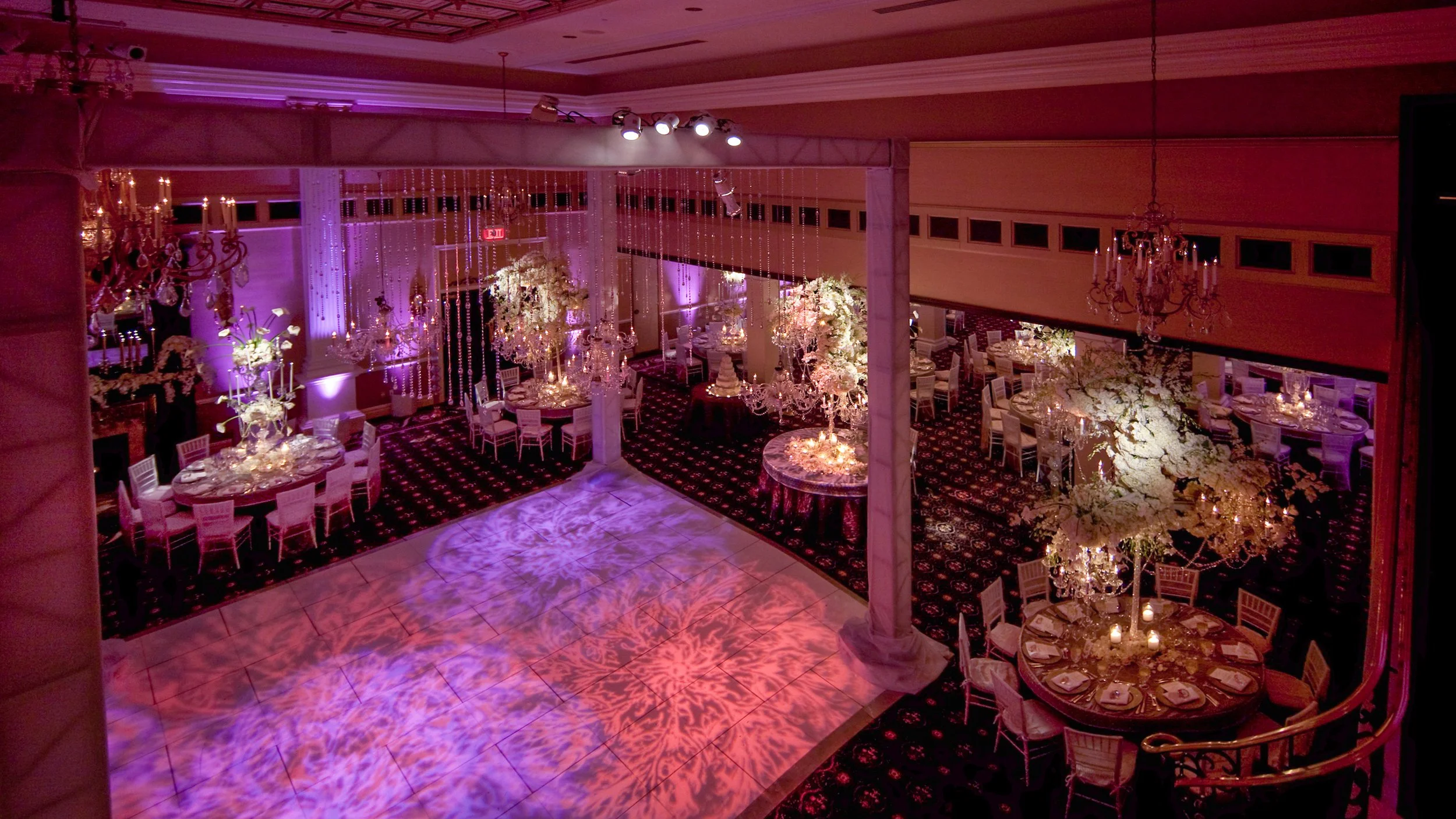 Wide-angle view of the reception ballroom at The Palace at Somerset Park, featuring elaborate tables and floral decor.