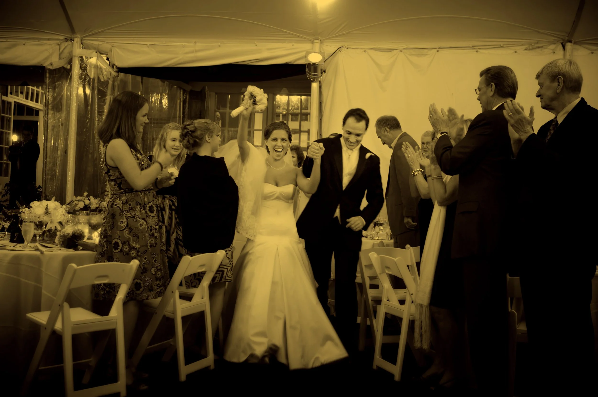 Fine art photograph of bride and groom joyfully entering their reception at Wainwright House.