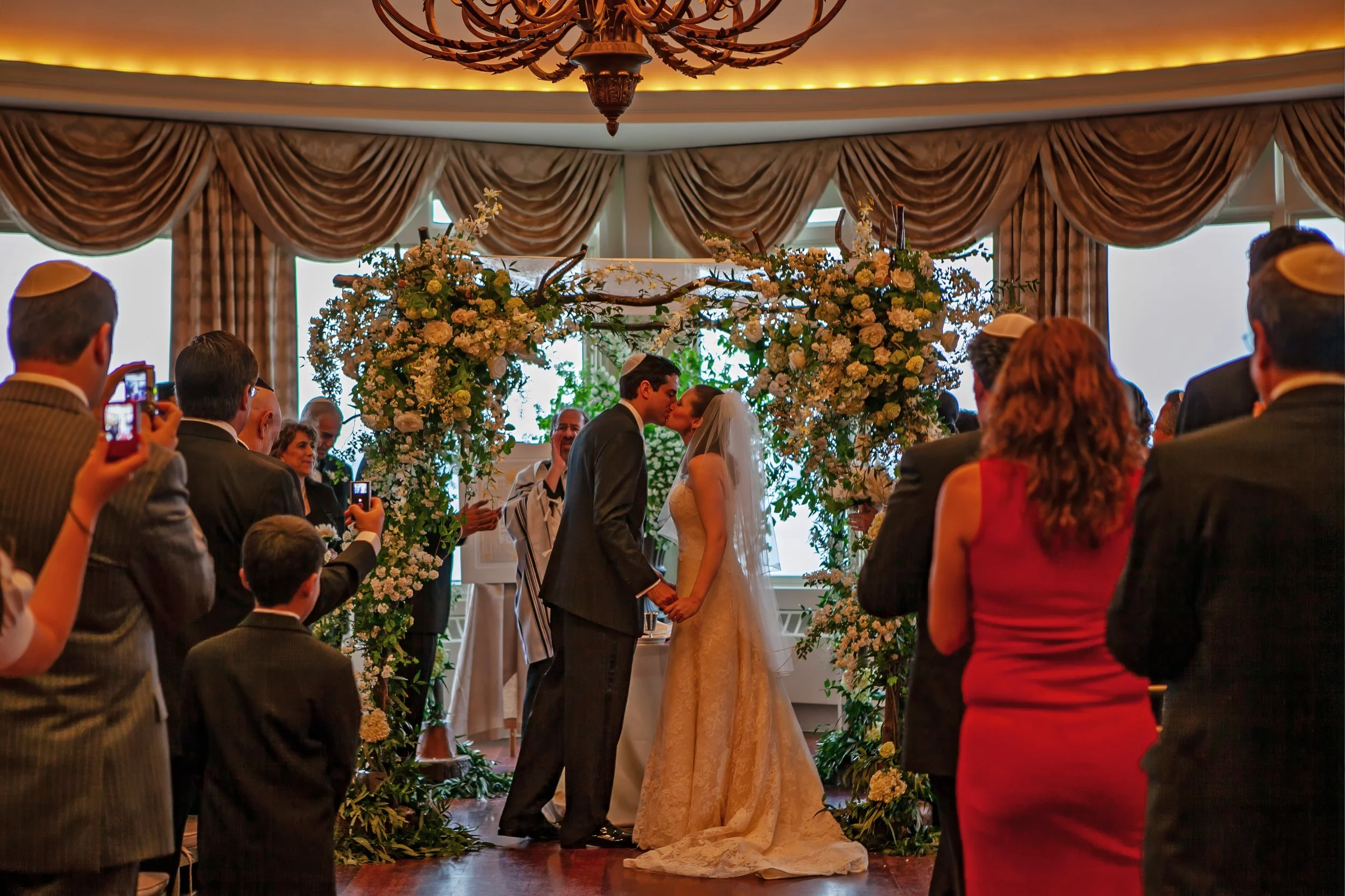 Bride and groom first kiss as husband and wife indoors at Ocean Cliff.