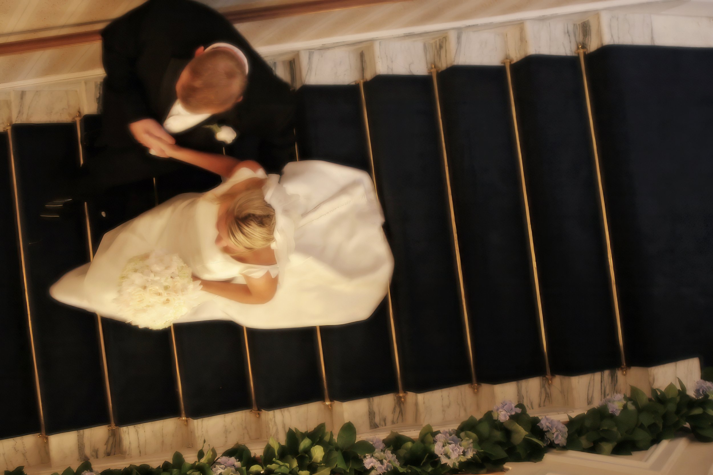 Bride and groom descending the grand staircase inside Wadsworth Mansion during their wedding celebration.