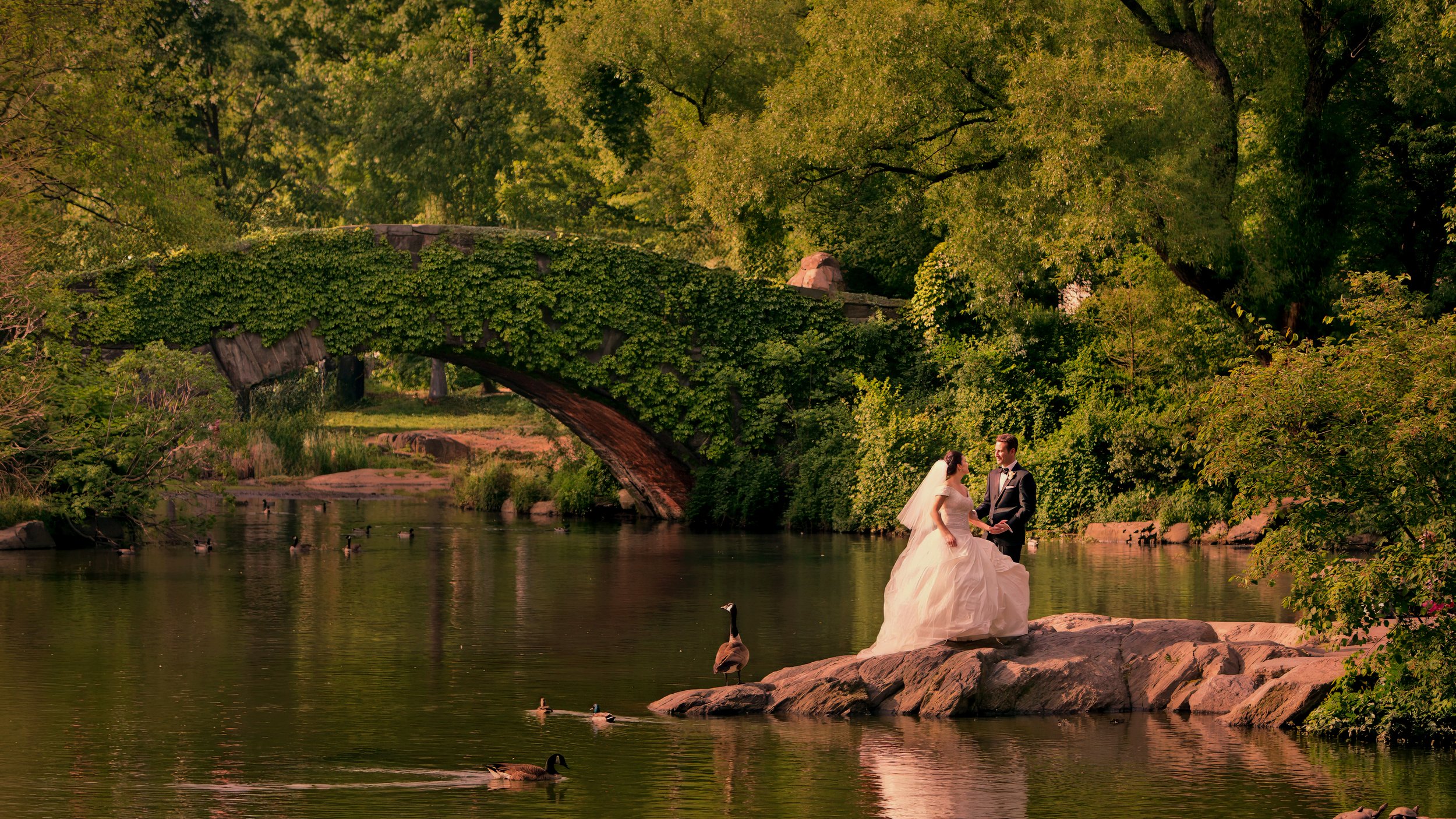 Bride and groom sharing a romantic moment at The Pond in Central Park near The St. Regis New York.