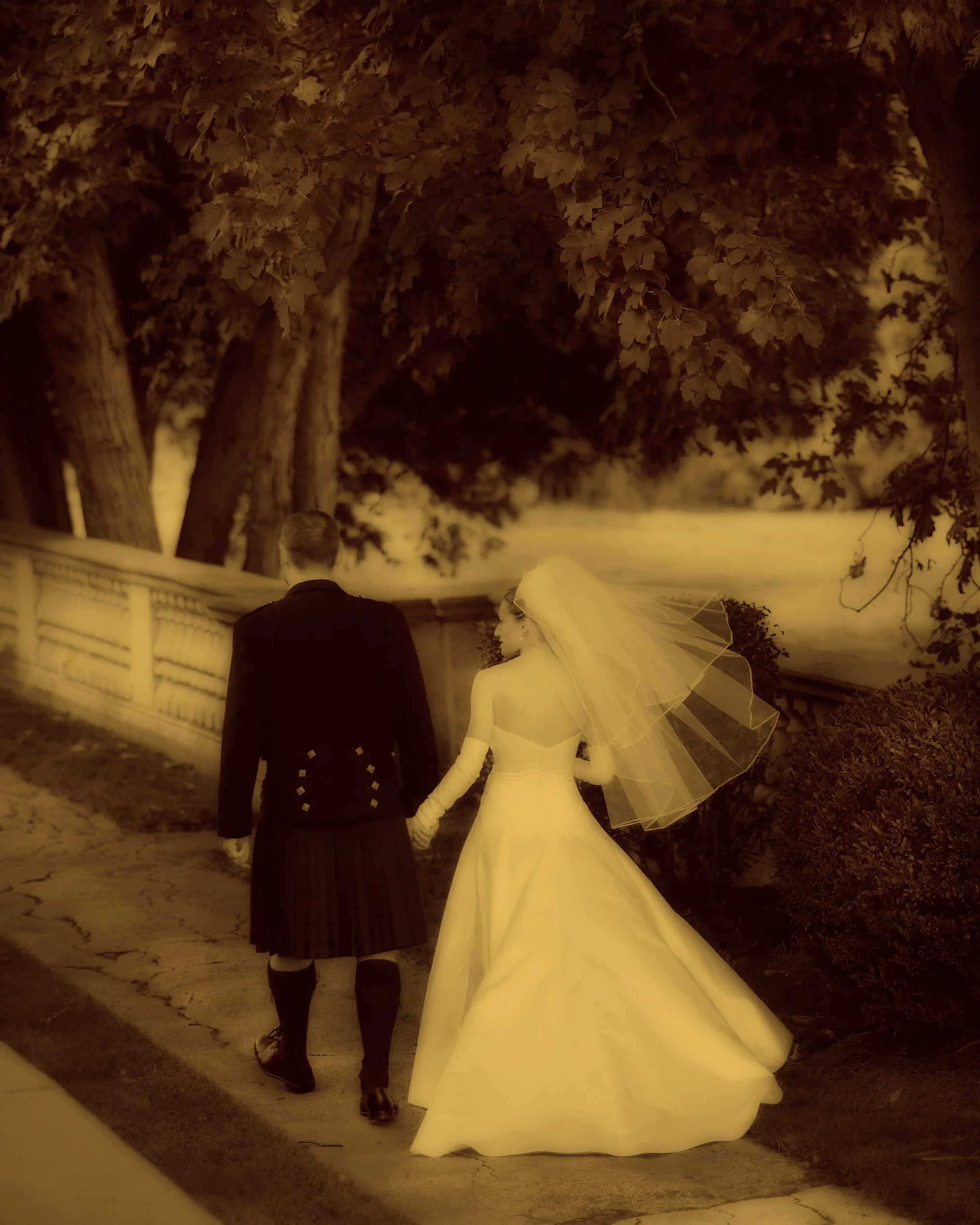 Bride and groom walking together through the scenic grounds of Aldrich Mansion in Warwick, Rhode Island.