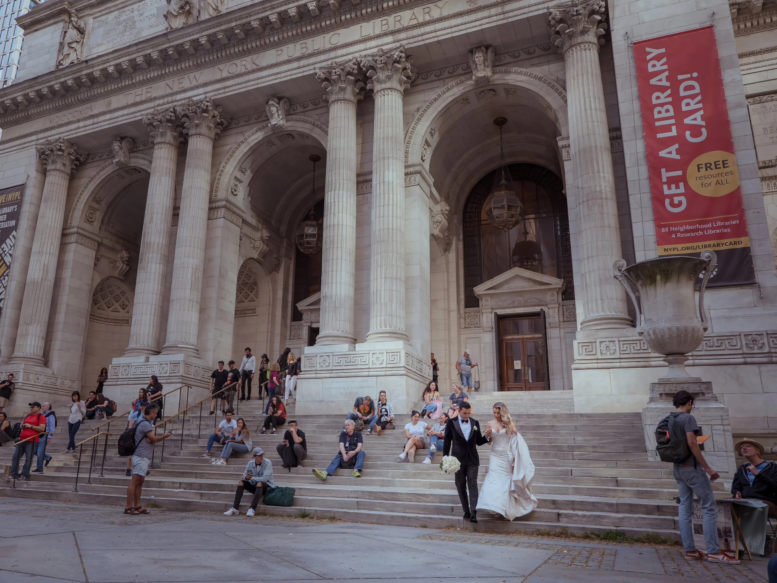 Bride and groom walking down the steps of the New York Public Library after wedding portraits in NYC
