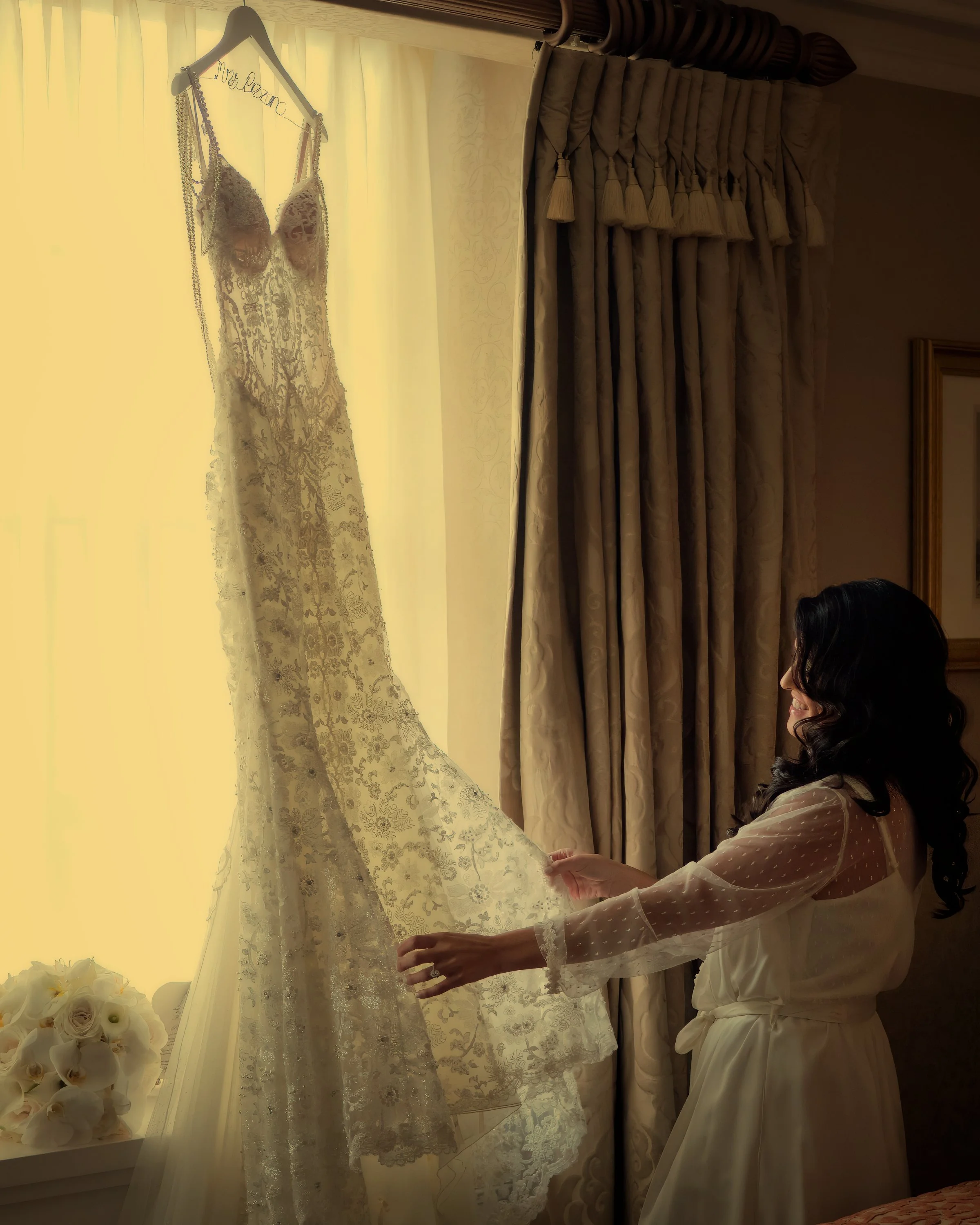 The bride admires her wedding dress in her suite at The Pierre Hotel NYC