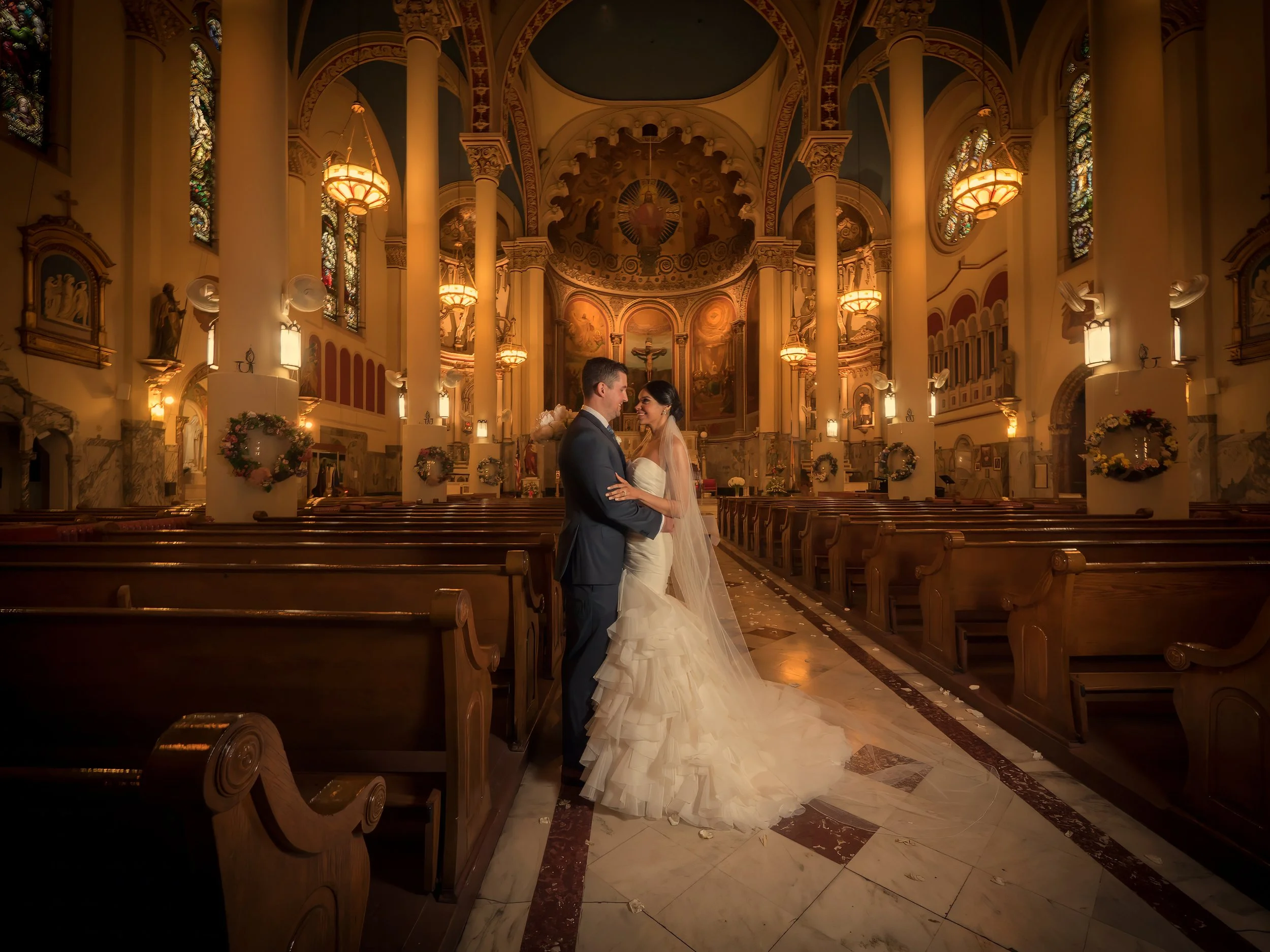 Bride and groom portrait in the center aisle of Most Holy Redeemer Church during their NYC wedding ceremony.
