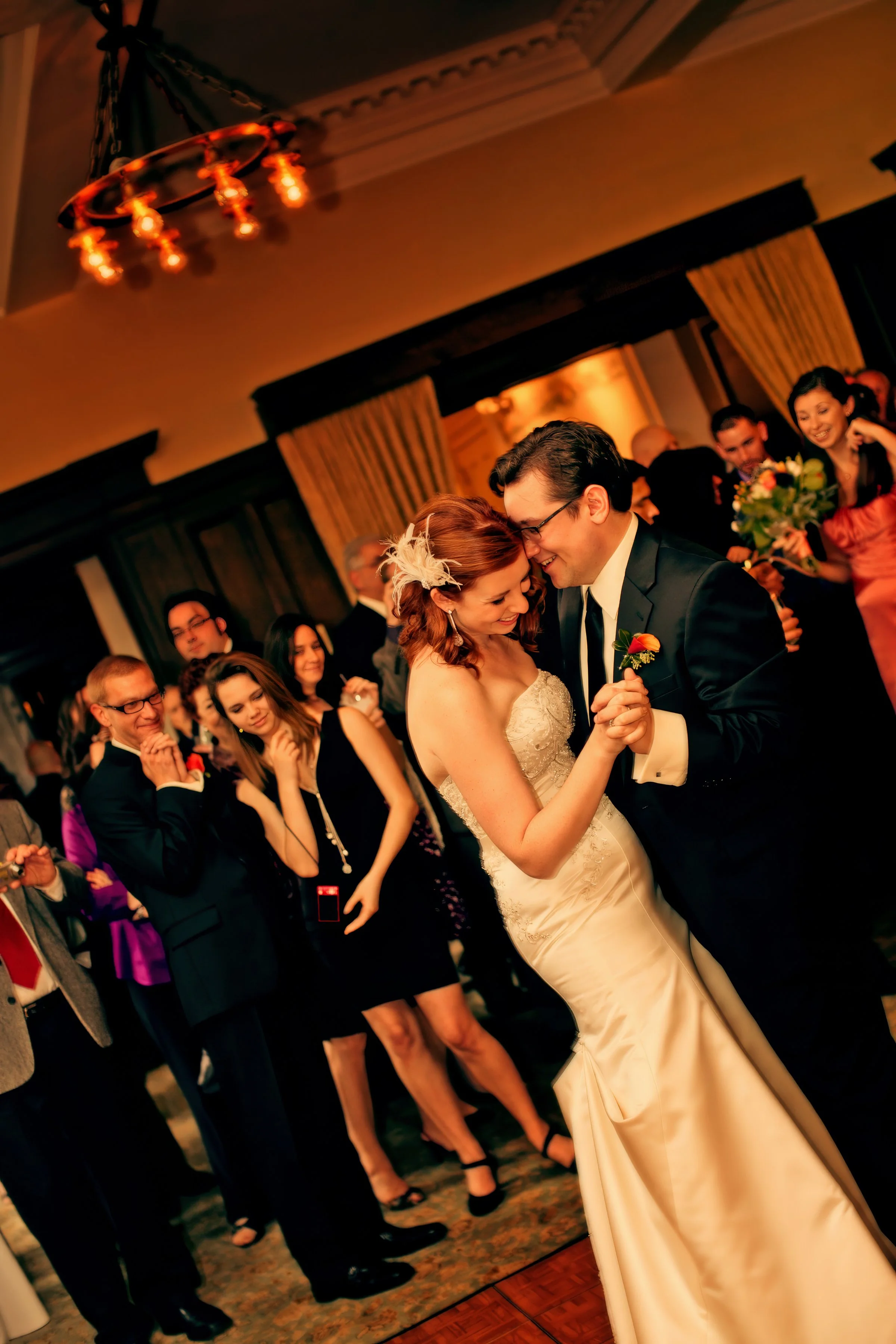 Joyful first dance of the couple at Union League Cafe surrounded by friends and family.