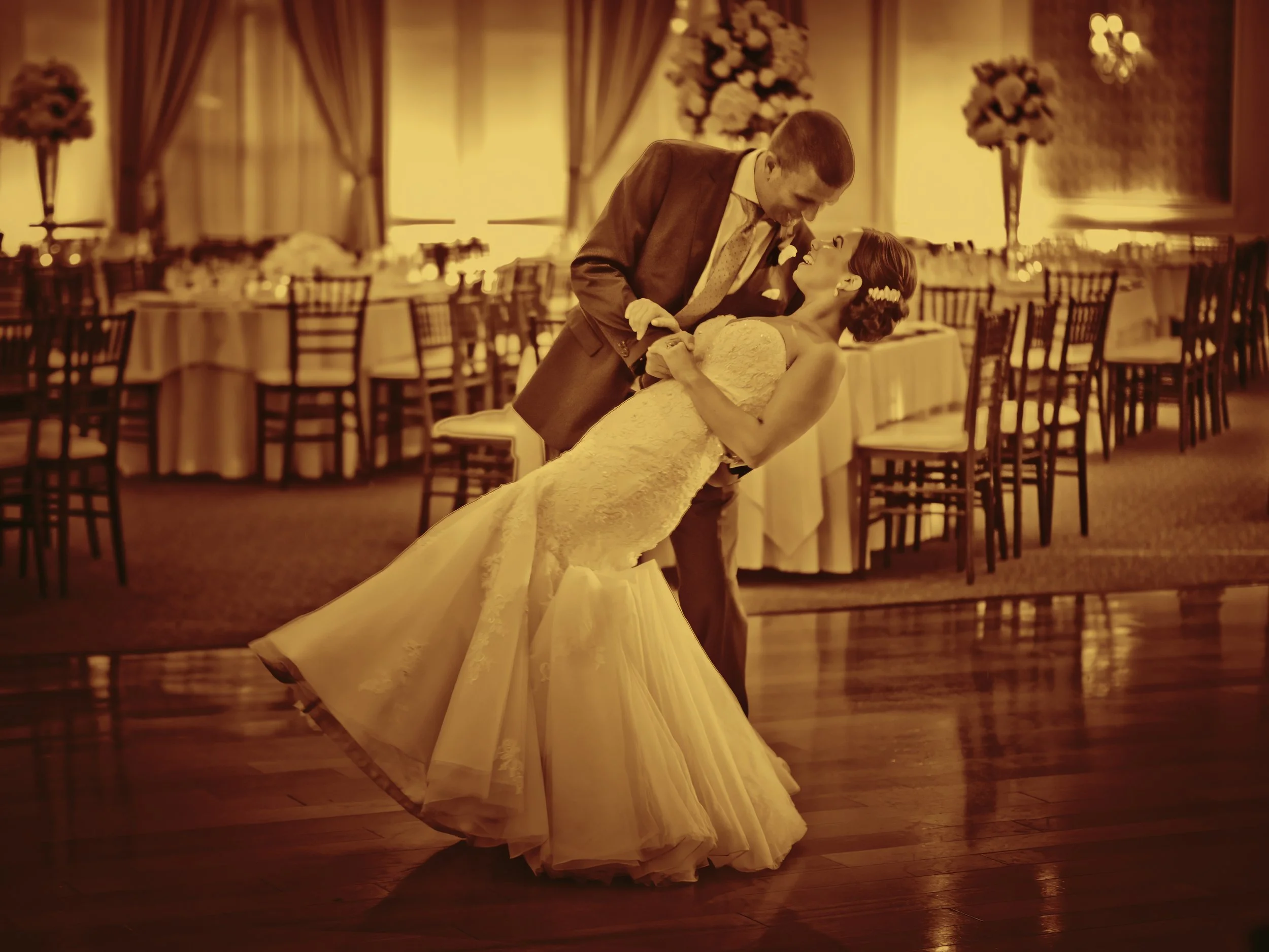 The groom dips the bride during their first ballroom dance at The Grandview.