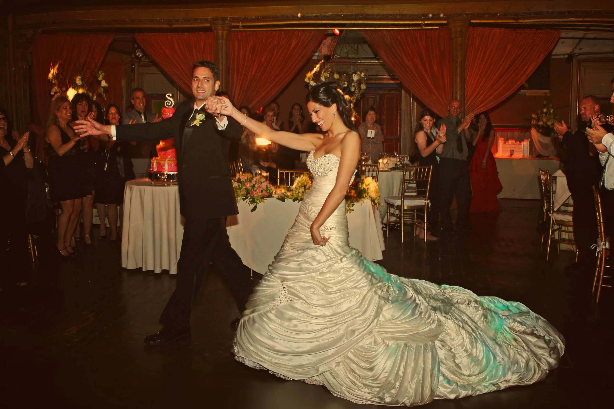 Bride and groom make a joyful grand entrance at their Angel Orensanz wedding reception.