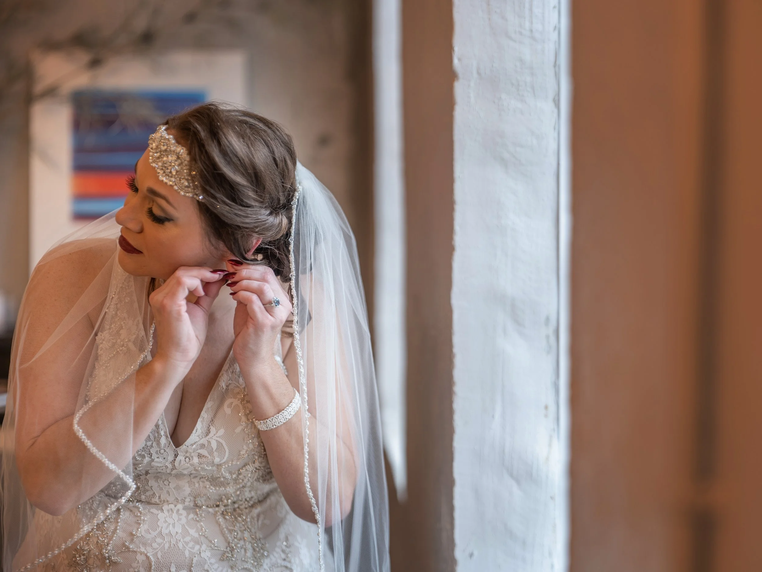 Bride puts on her earrings in the loft at Victory North Savannah