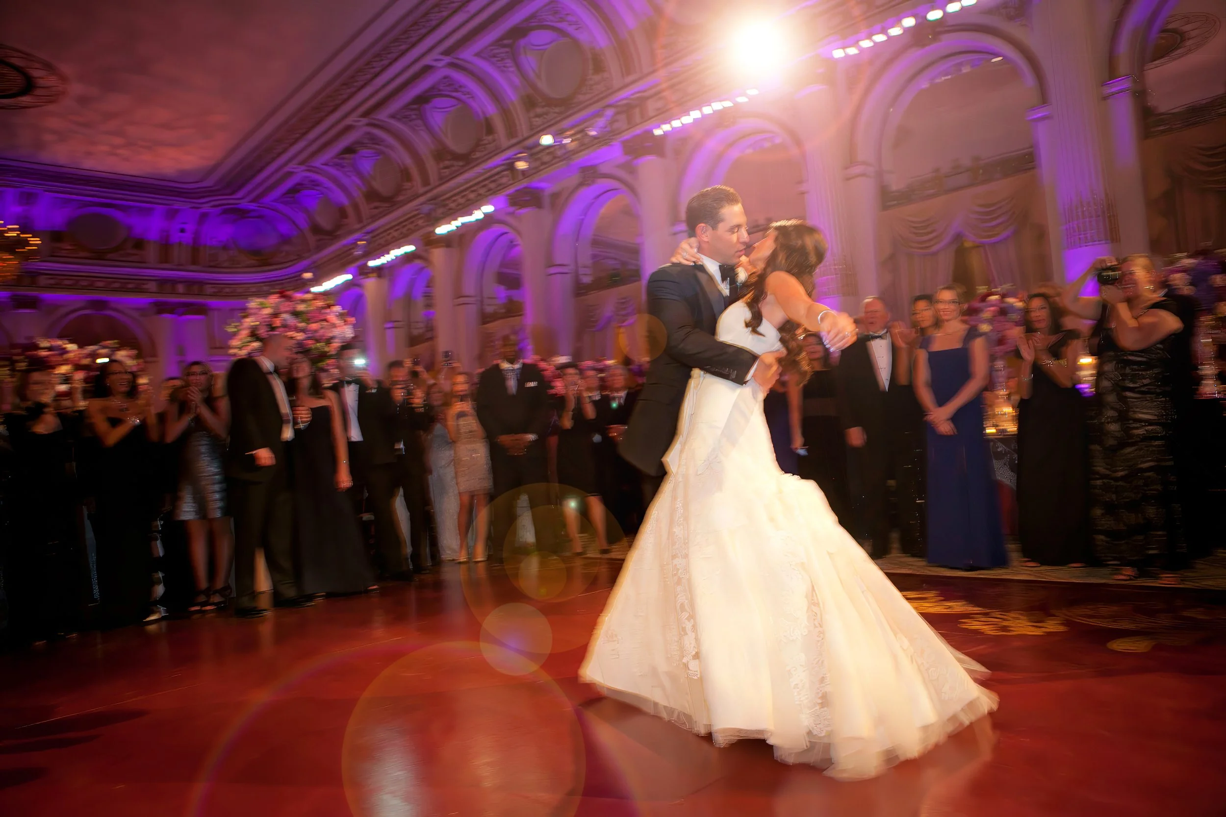 Bride and groom sharing their first dance in the elegant ballroom during a wedding reception at The Plaza Hotel in New York City.