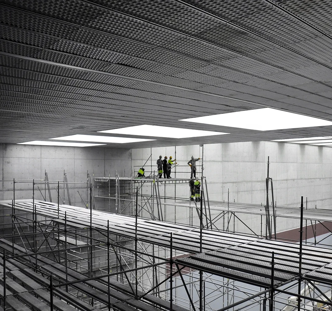 Trabajo interior a gran escala con operarios sobre andamios certificados, reflejando la supervisión técnica, el control de calidad y la gestión rigurosa que caracteriza a ruiz pardo – nebreda en cada fase de obra.