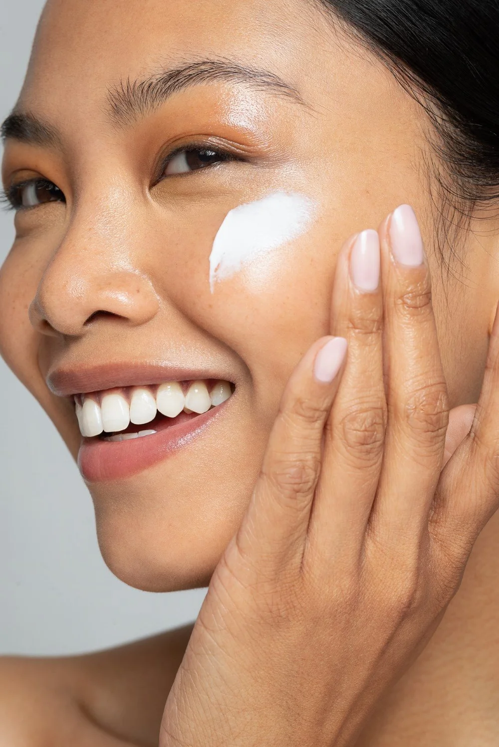 Smiling model applying skincare — Patrick D. Simmons Photography