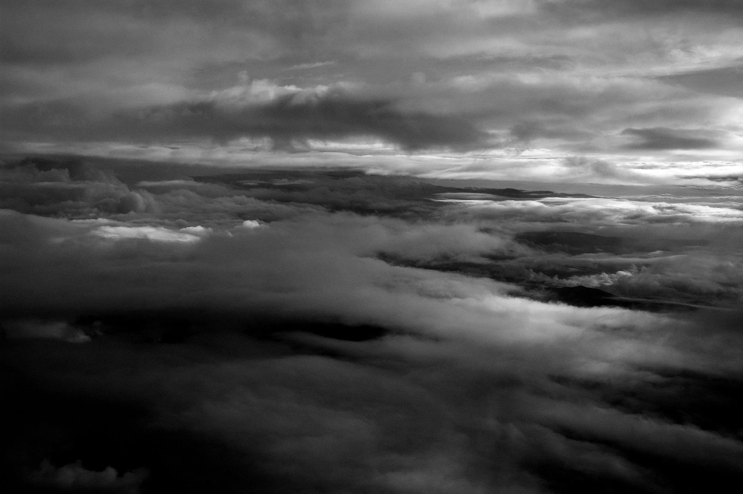 Black and white photo of cloudy sky with layers of clouds at various altitudes.