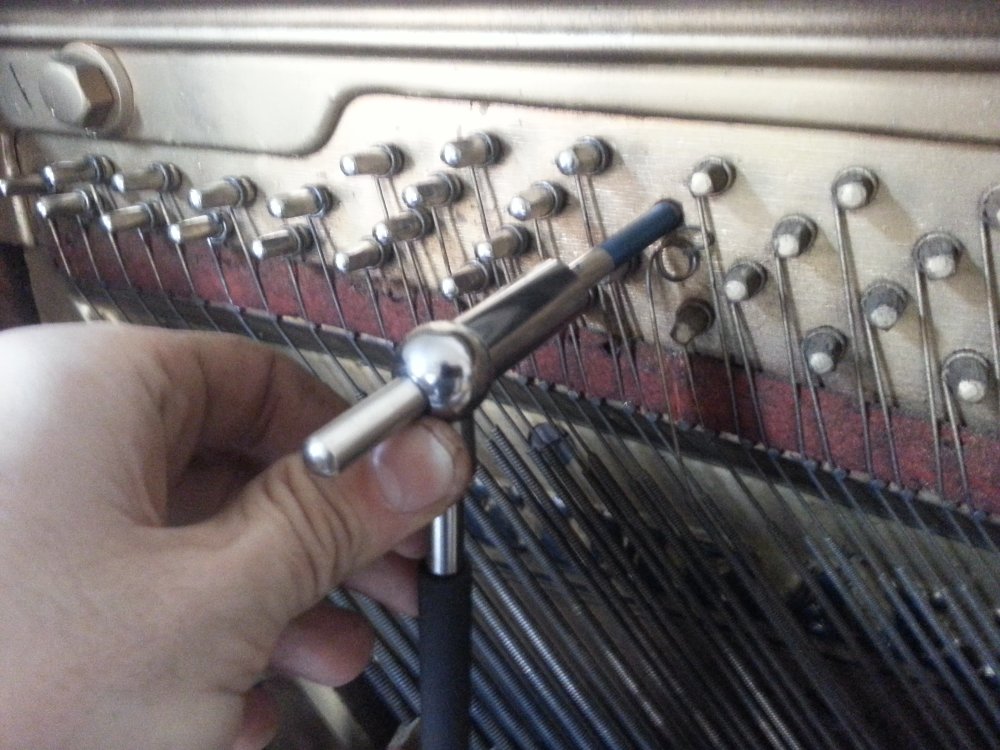 The tuning pin setter and the new tuning pin ready to be hammered into the pinblock.