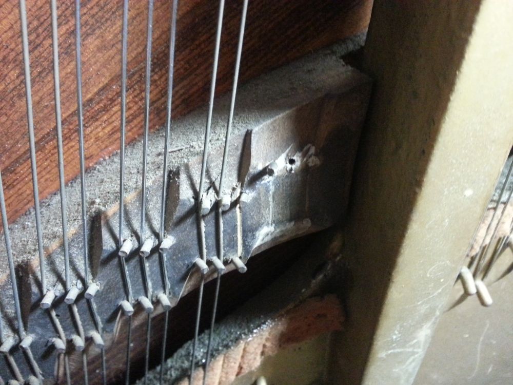 The bridge with one pin re-installed and a second hole drilled.