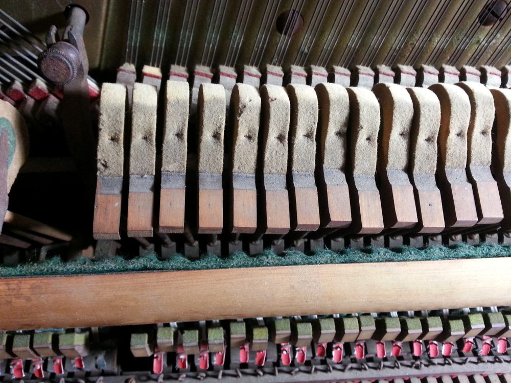 The small "wells" that the hammer shanks have made in the felt are a sign that it should be replaced.