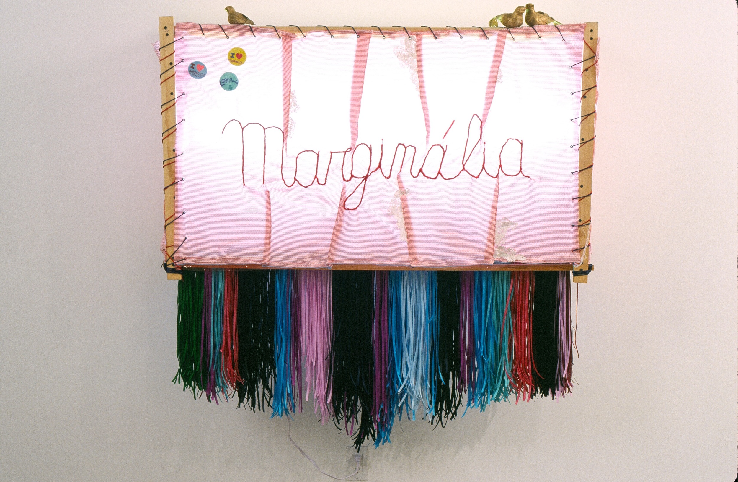  I Love Marginália , 2004  fabric, wood, mesh wire, ribbons, styrofoam, buttons, paint, light, vinyl, metal, paper   74 X 18 X 50 / 188 X 45.5 x 127Cm     