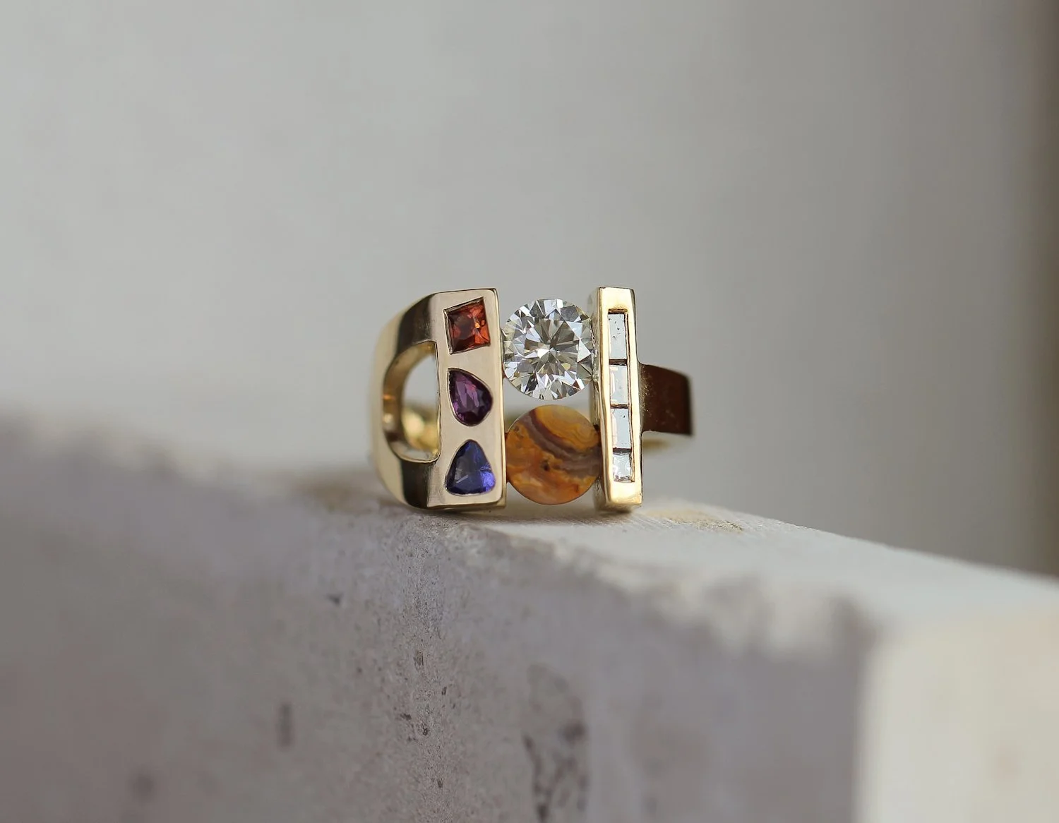 Diamond and lace agate centre stones, combined with coloured sapphires, and a row of baguette cut champagne diamonds