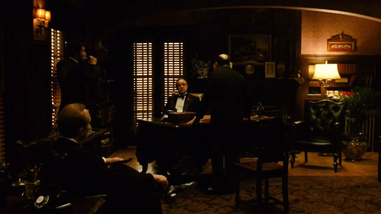 typical gordon willis frame. lots of head to toe framing and super naturalistic and dark lighting.