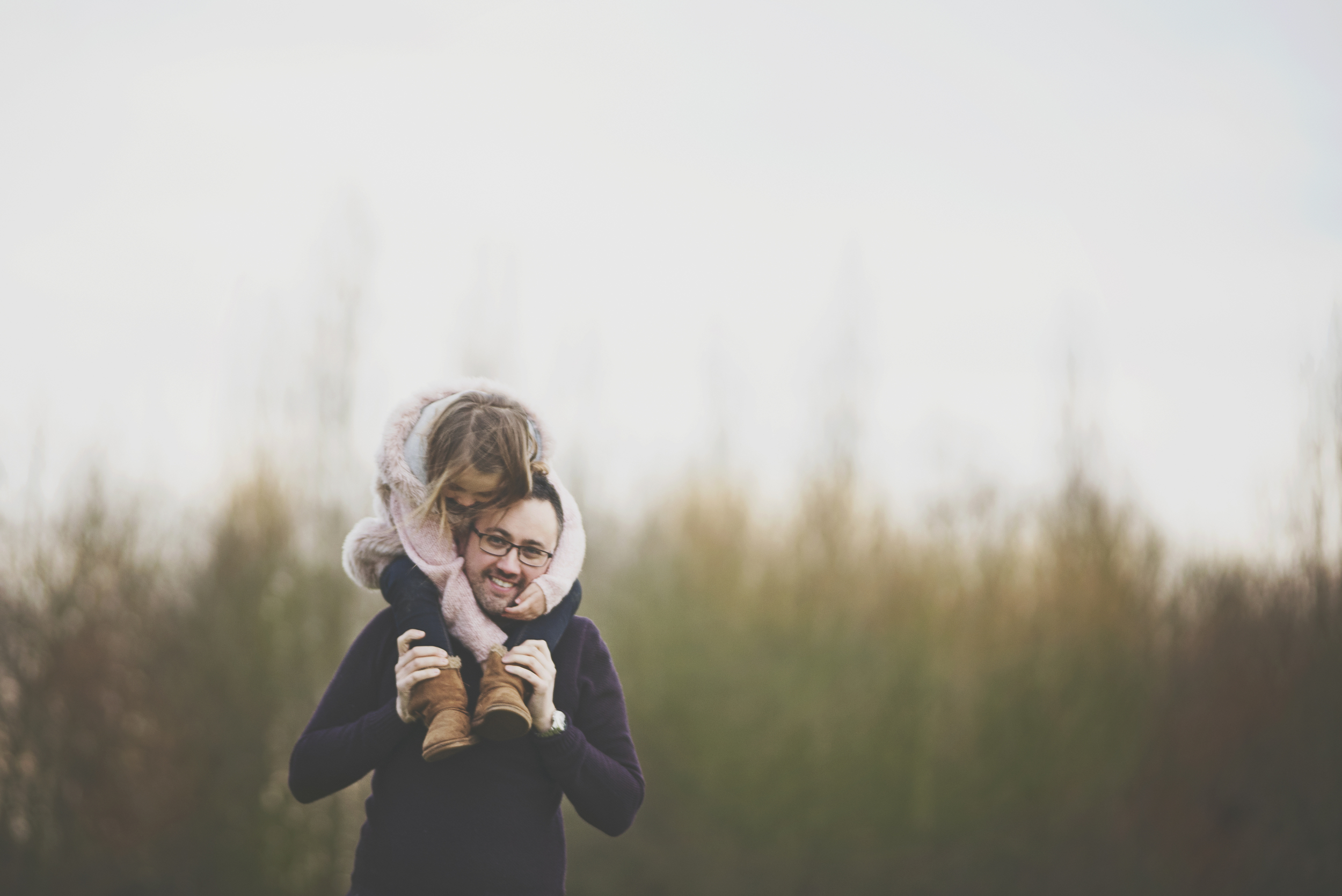 Little girl sits on dads shoulders Essex Documentary Portrait Photographer