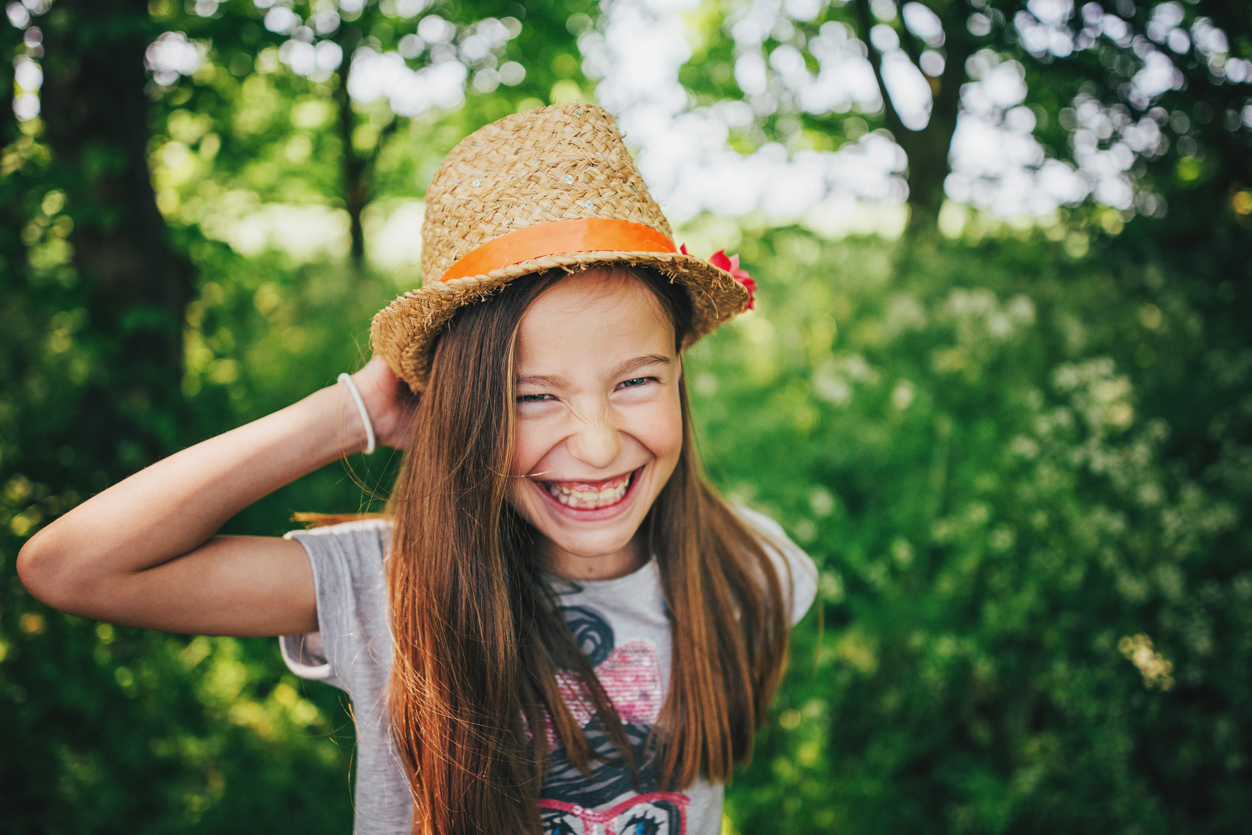 Girl in sunhat laughs in field Essex UK Documentary Portrait and Lifestyle Photographer