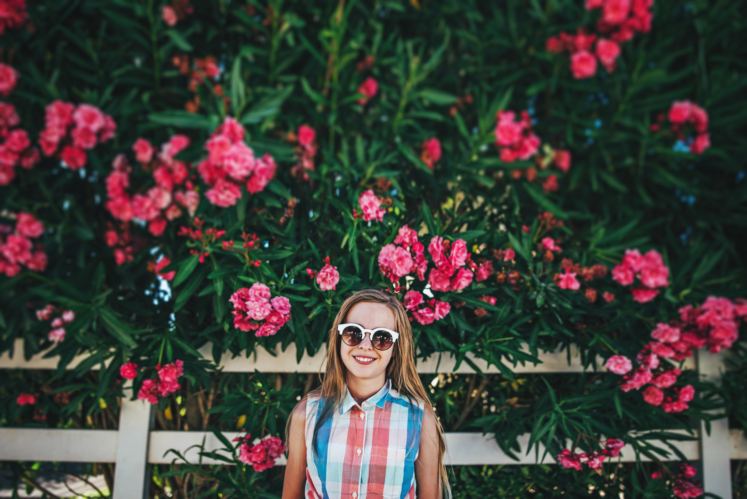 Young girl in sunglasses by Pink Blossom tree Essex UK Documentary Portrait Photographer