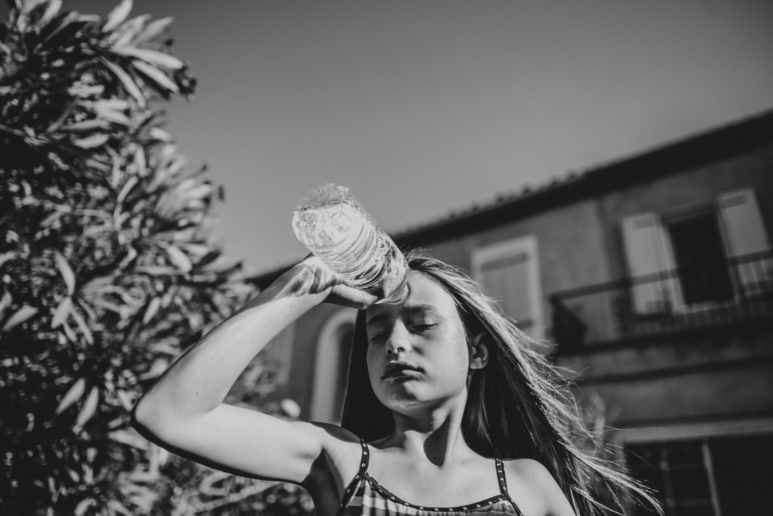 Young girl pours water over face Essex UK Documentary Portrait Photographer