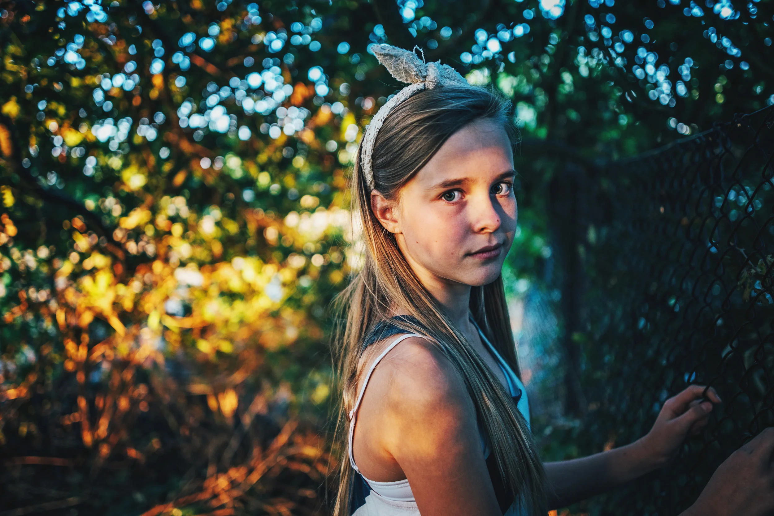Girl stands among trees at sunset golden hour Essex UK Documentary Portrait Photographer