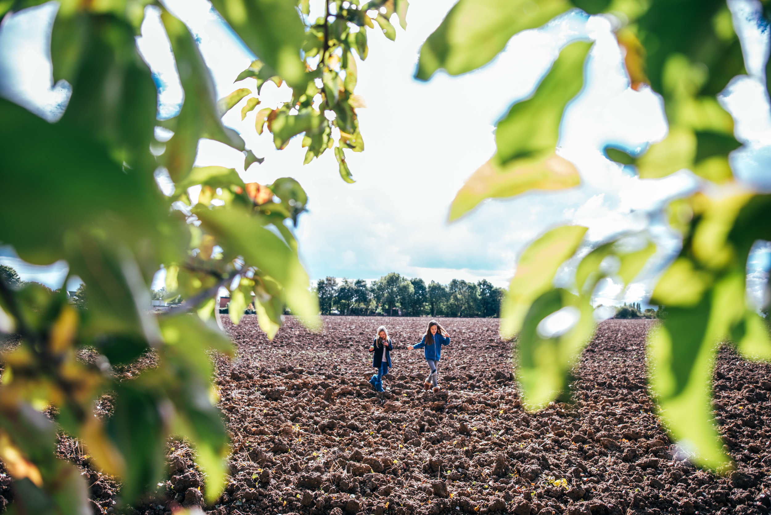 Girls in a field framed by trees Essex UK Documentary Portrait Photographer