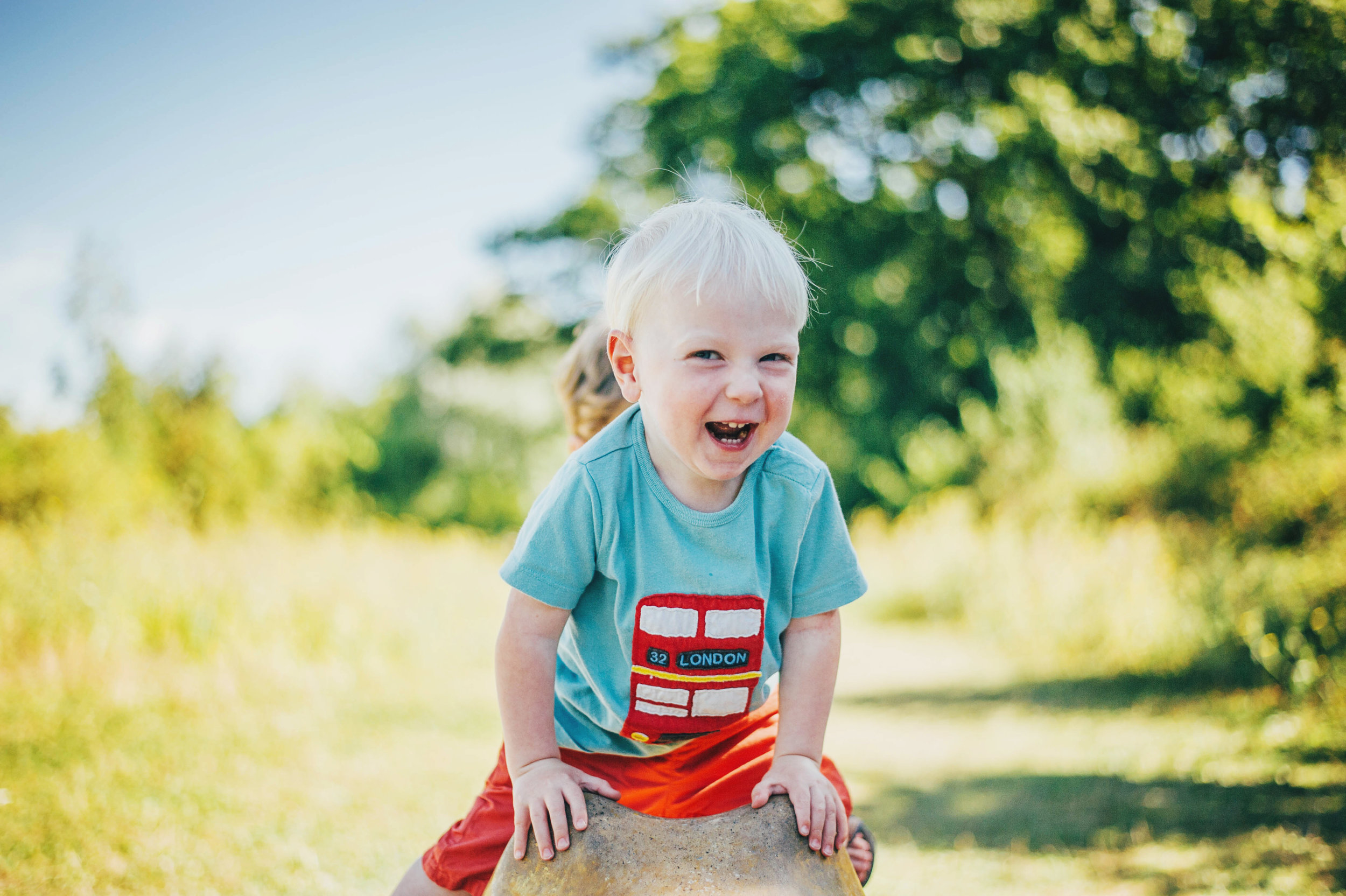 Little boy laughs in park Essex UK Documentary Portrait Photographer