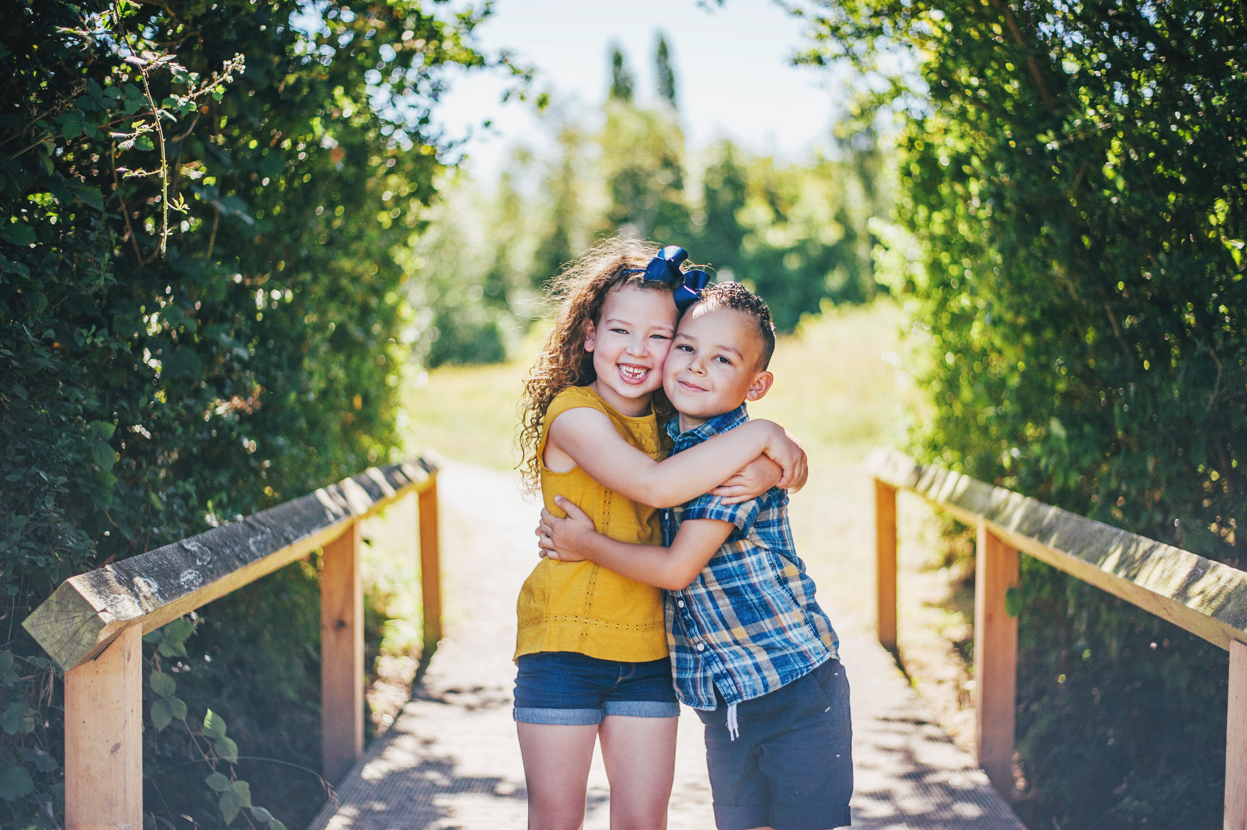 Brother and Sister hug on a bridge Natural Essex UK Documentary Portrait Photographer