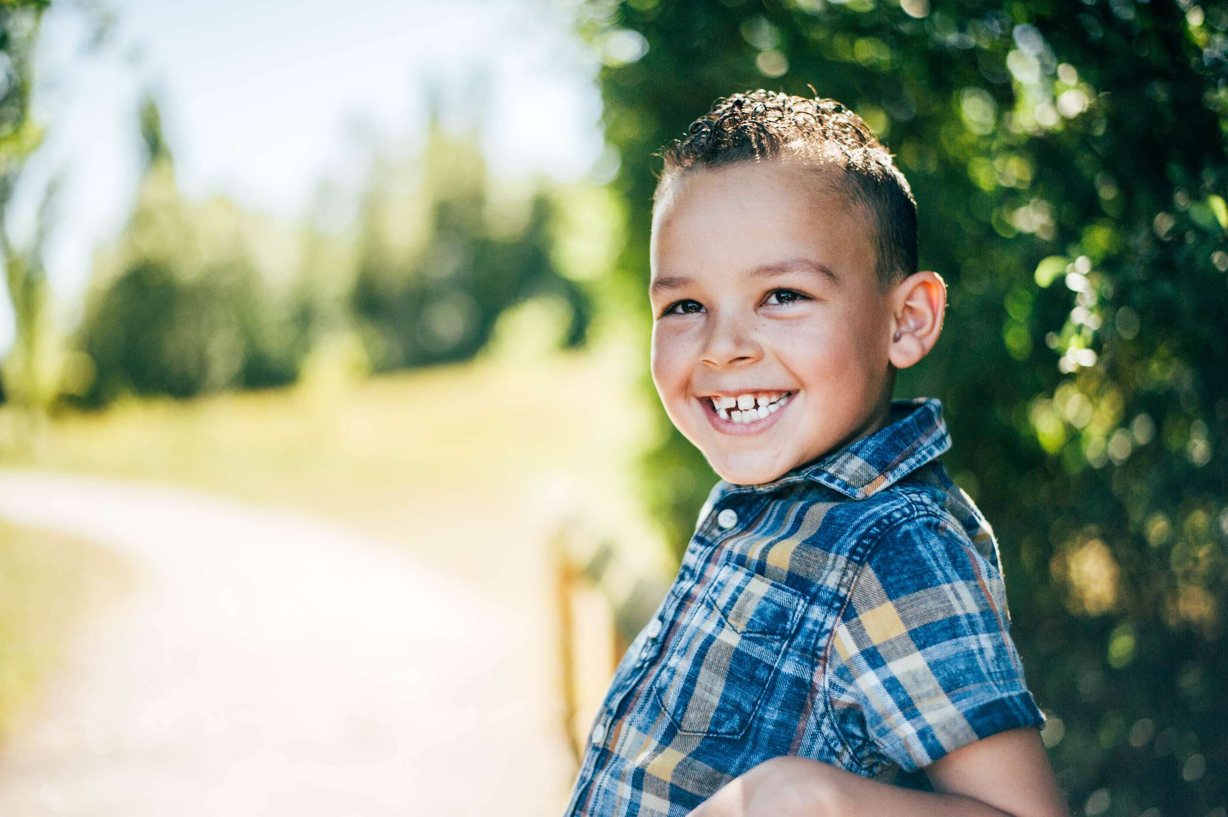 Boy smiles on bridge Essex UK Natural Documentary Portrait Photographer